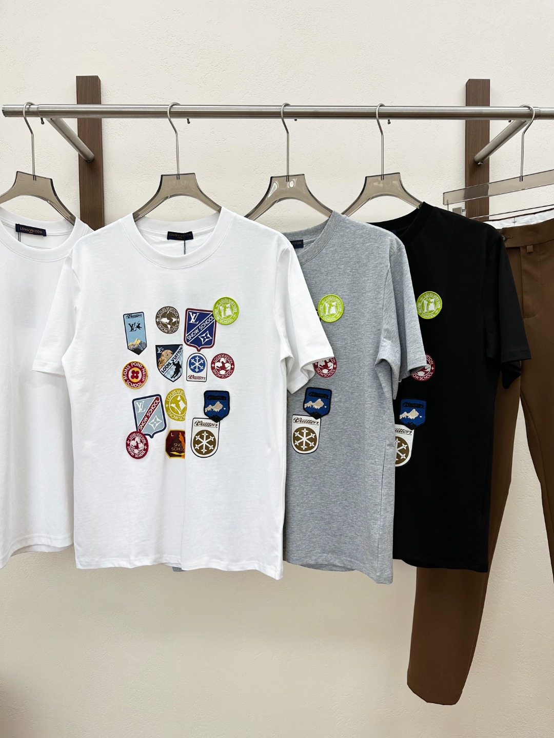 NO:849990,[New Products] 2026 spring and summer new models are synchronized with the official website!  1V fashionable colorful multi-emblem decorated short-sleeved T-shirt for men and women. This T-shirt is made of custom-made plain knitted cotton. The fabric texture is fine and tight. It not only feels comfortable to the touch, like gentle clouds brushing over the skin, but also has good breathability and moisture absorption!  Whether you are wearing it in the hot summer or wearing it for a long time, it can keep your skin dry and away from the discomfort of stuffiness and stickiness!  The front design is full of eye-catching features and is decorated with colorful badges. Each badge is like an independent small world, containing unique stories and charm!  The design inspiration of these badges comes from a wide range of sources. After the designers' ingenious conception and careful combination, they form a colorful picture!  The badge uses top-notch printing technology and exquisite embroidery patches. In terms of printing technology, it uses advanced digital printing technology. This technology can accurately restore every detail of the design pattern, with bright colors and high saturation, as if a vivid painting is printed directly on the T-shirt!  In terms of embroidery, professional embroidery craftsmen rely on their superb skills to embroider lifelike patterns on the T-shirts with silk threads as thin as hair!  The fitting design is determined through a large amount of human body data research and repeated trial adjustments. It can perfectly fit the body curves, and is neither too tight to make people feel restricted nor too loose to make them bloated!  Color Black White Gray Size S M L  XXL size shoulder width 51cm - bust 122cm - length 76cm, T-shirt, tees, t-shirt,19860909【新品】2026春夏新款官网同步！1V时尚彩色多徽章装饰男女同款情侣短袖T恤.这款T恤采用客供定制平纹针织棉布,面料纹理细腻而紧密,不仅触感舒适,如同轻柔的云朵拂过肌肤,还具有良好的透气性和吸湿性！无论是在炎炎夏日,还是长时间穿着,都能让你的肌肤保持干爽,远离闷热和黏腻的不适感！前幅设计充满了令人眼前一亮的吸睛度,布满了彩色多徽章装饰,每一个徽章都像是一个独立的小世界,蕴含着独特的故事和魅力！这些徽章的设计灵感来源广泛,经过设计师的巧妙构思和精心组合,形成了一幅绚丽多彩的画卷！徽章采用顶级印花工艺和精湛刺绣贴饰,在印花工艺方面,运用了先进的数码印花技术,这种技术能够精准地还原设计图案的每一个细节,色彩鲜艳且饱和度高,仿佛将一幅生动的画作直接印在了T恤上！刺绣方面由专业的刺绣工匠们凭借着精湛的技艺,将一根根细如发丝的丝线,在T恤上绣出了栩栩如生的图案！合身版型设计,经过大量的人体数据研究和反复试穿调整而确定的,它能够完美地贴合身体曲线,既不会过于紧身让人感到束缚,也不会过于宽松显得臃肿！ 颜色黑色 白色 灰色 尺码S M L XL XXL 尺码数据 S码肩宽47cm-胸围104cm-衣长68cm M码肩宽48cm-胸围108cm-衣长70cm L码肩宽49cm-胸围112cm-衣长72cm XL码肩宽50cm-胸围117cm-衣长74cm XXL码肩宽51cm-胸围122cm-衣长76cm,,T-shirt,tees，t-shirt,,Men's clothing