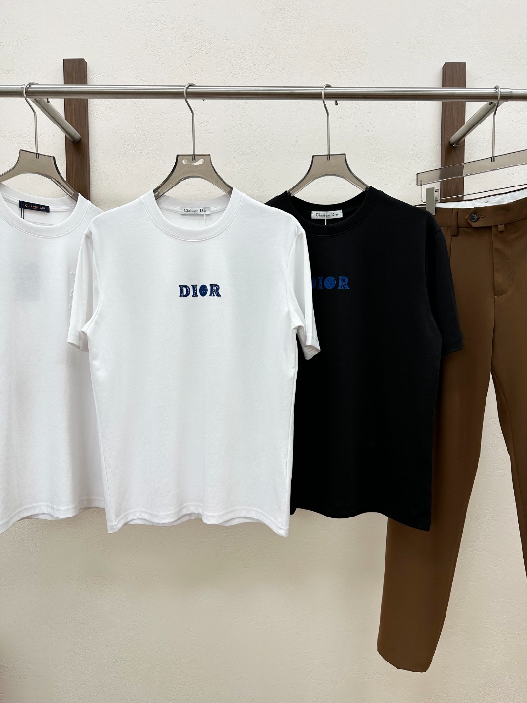 NO:849984,[New Product] 2026 spring and summer new D*or men’s and women’s co-branded logo embroidered short-sleeved T-shirts!  This T-shirt is made of custom-made technical fiber blended cotton. The addition of technical fiber gives the cotton a new vitality!  It not only retains the natural breathability and moisture absorption of cotton, allowing the skin to breathe freely during wearing, keeping it dry and comfortable at all times!  The exquisite embroidered patch of joint letters logo on the chest is undoubtedly the finishing touch of the entire outfit!  The color matching of the embroidery is also very particular. It complements the overall tone of the T-shirt, which is not obtrusive but also attracts the eye!  This joint letter logo is not just a decoration, it is a status symbol, representing high luxury and quality!  When you walk on the street wearing this T-shirt with an embroidered patch of the joint letter logo, it is as if you are announcing to the world your unique taste in fashion and your pursuit of high-quality life, instantly becoming the focus of fashion in everyone's eyes!  The fitted design is neither too tight, making you feel cramped, nor too loose, making you look bloated. It can cleverly outline your body lines and show off your graceful figure!  Color Black White Size S M L  XXL size shoulder width 51cm - bust 122cm - length 74cm, T-shirt, tees, t-shirt,19860909【新品】2026春夏新款D*or男女同款联名徽标刺绣短袖T恤！这款T恤采用客供定制科技纤维混纺棉布,科技纤维的加入,为棉布赋予了全新的生命力！它不仅保留了棉布天然的透气性和吸湿性,让肌肤在穿着过程中能够自由呼吸,时刻保持干爽舒适！胸前精致的联名字母徽标刺绣贴饰,无疑是整件衣服的点睛之笔！刺绣的色彩搭配也十分讲究,与T恤的整体色调相得益彰,既不突兀又能吸引眼球！这个联名字母徽标不仅仅是一个装饰,它更是一种身份的象征,代表着高奢与品质！当你穿着这件带有联名字母徽标刺绣贴饰的T恤走在街头,就仿佛在向世人宣告你对时尚的独特品味和对高品质生活的追求,瞬间成为众人眼中的时尚焦点！合身版型设计既不过于紧身,让你感到局促不安,也不过于宽松,显得拖沓臃肿,它能够巧妙地勾勒出你的身体线条,展现出你的优美身姿！ 颜色黑色 白色 尺码S M L XL XXL 尺码数据 S码肩宽47cm-胸围104cm-衣长68cm M码肩宽48cm-胸围108cm-衣长69cm L码肩宽49cm-胸围112cm-衣长70cm XL码肩宽50cm-胸围117cm-衣长72cm XXL码肩宽51cm-胸围122cm-衣长74cm,,T-shirt,tees，t-shirt,,Men's clothing