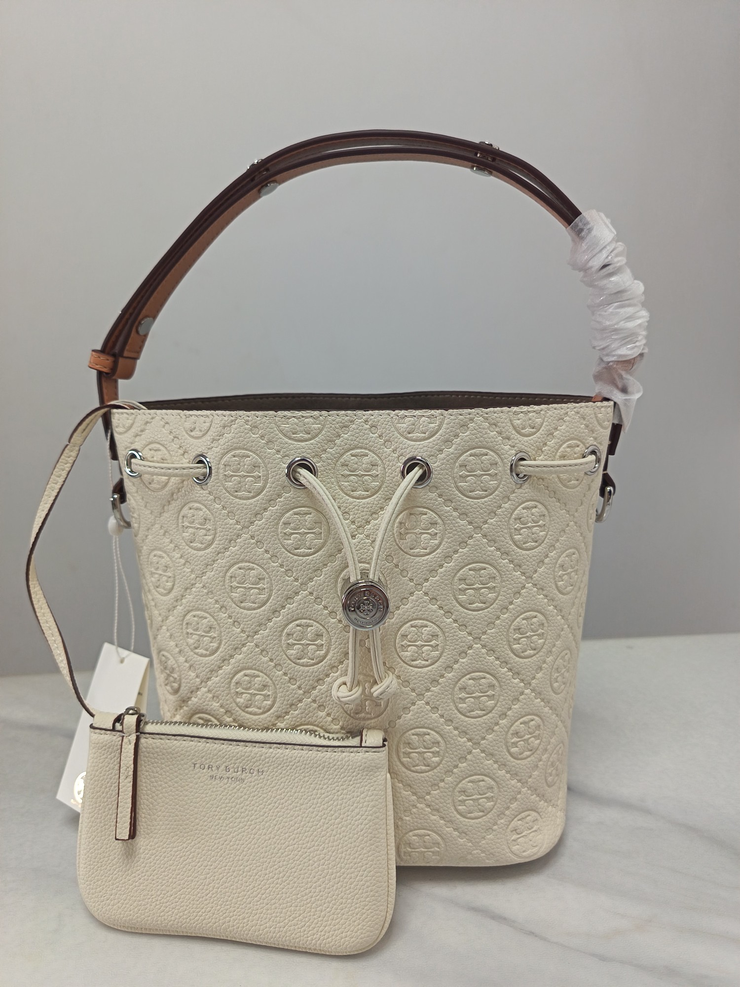 Tory Burch ～TB新款T Monogram 桶包 大号 图案 精选荔枝纹压花牛皮 该系列魅力隽永