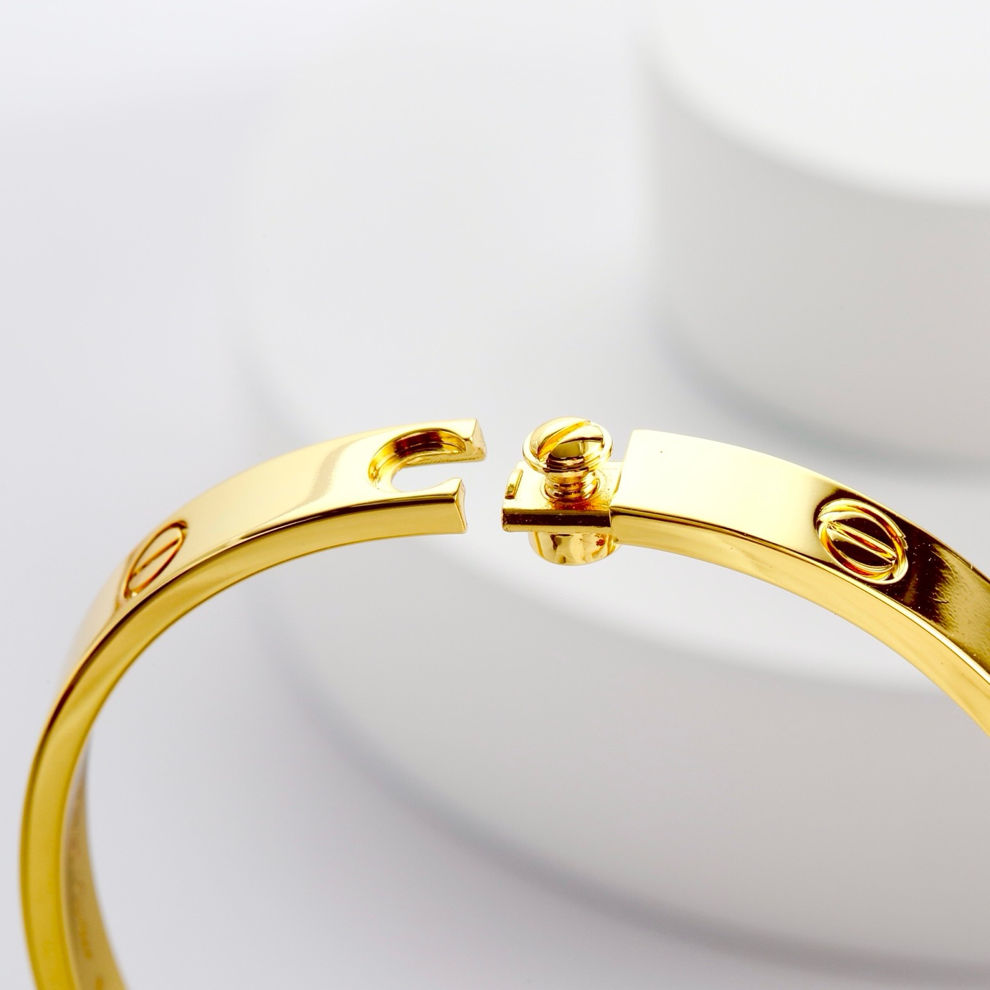 Cartier 卡地亚的Love系列手镯以其独特的设计而备受喜爱 这款宽版无钻玫瑰金手镯更是爱情的完美见证