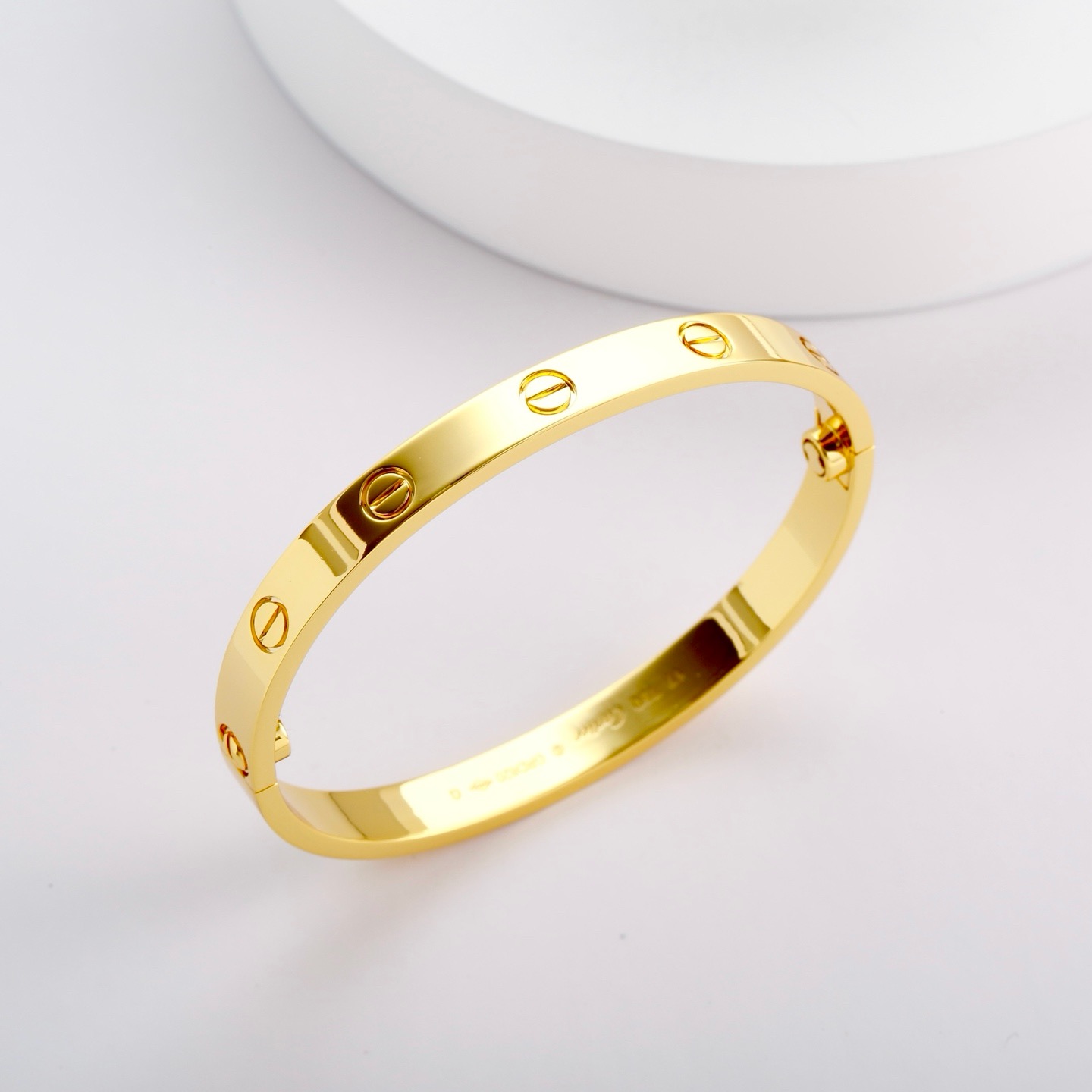 Cartier 卡地亚的Love系列手镯以其独特的设计而备受喜爱 这款宽版无钻玫瑰金手镯更是爱情的完美见证