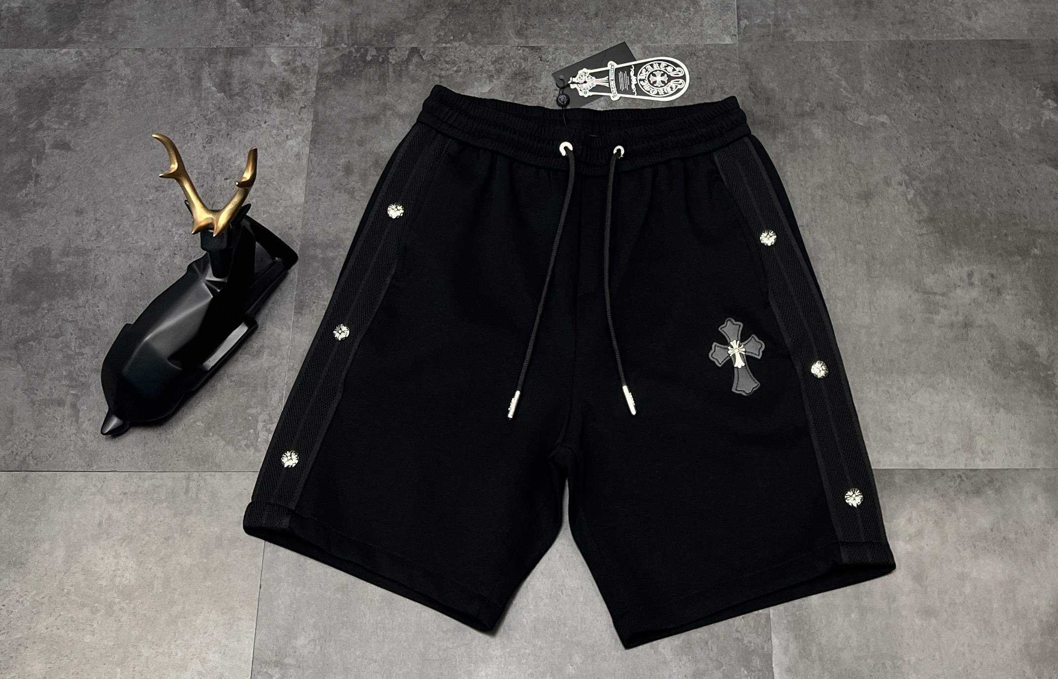 NO:935305,(Top replica version) New shorts, 2025SS new summer products, Chrome Hearts 11, Chrome Hearts Cross, heavy craftsmanship, leather label, rivet embroidery shorts | must-have shorts for dark fashionistas. My family, I have found another treasure!  These shorts of Crow Heart are simply a god in the fashion circle!  When I got it, I was amazed by the texture. The fabric is made of high-quality cotton blend, which is skin-friendly and breathable. It is very comfortable to wear and does not feel stuffy at all. It has a slightly loose fit and is not picky about your figure. If you wear it casually, you will look like the coolest kid on the street.  The design brings the dark and gorgeous style of Crow Heart to the extreme. The Sanskrit silver buckles on the sides shine with a mysterious luster under the light, and each one is extremely exquisite. The iconic cross leather label on the front is matched with a metal cross, which is full of three-dimensionality and instantly enhances the grade. The carved metal head on the top of the drawstring in the details shows the brand's ingenuity. Whether these shorts are paired with a simple white T or a dark top of the same style, you can easily grasp the trend and turn heads when you go out on the street!  Color Black Size M L XL 2XL 3XL,,chrome hearts,chrome hearts,shorts,19860909（顶级复刻版本） 新款短裤上新2025SS夏季新品 Chrome Hearts 11 克罗心十字架 重工艺贴皮标铆钉刺绣短裤 | 暗黑系潮人必备短裤 家人们,又被我挖到宝了！克罗心这条短裤简直是时尚圈的神！ 拿到手就被质感惊艳到,面料是高品质棉质混纺,亲肤又透气,穿起来舒适度拉满,完全不会有闷热感.微宽松版型,不挑身材,随意一搭就是街头最酷的仔. 设计上更是把克罗心的暗黑华丽风发挥到极致.侧边的梵文银扣排列,在光线下闪耀着神秘光泽,每一颗都精致无比.正面标志性的十字皮标搭配金属十字架,立体感十足,瞬间提升了档次.细节处抽绳顶端的雕花金属头,更是彰显品牌匠心. 这条短裤无论是搭配简单白T,还是同风格的暗黑上衣,都能轻松拿捏潮流感,出街回头率爆表！ 颜色黑色 尺码M L XL 2XL 3XL,,chrome hearts,chrome hearts,shorts,,Men's clothing