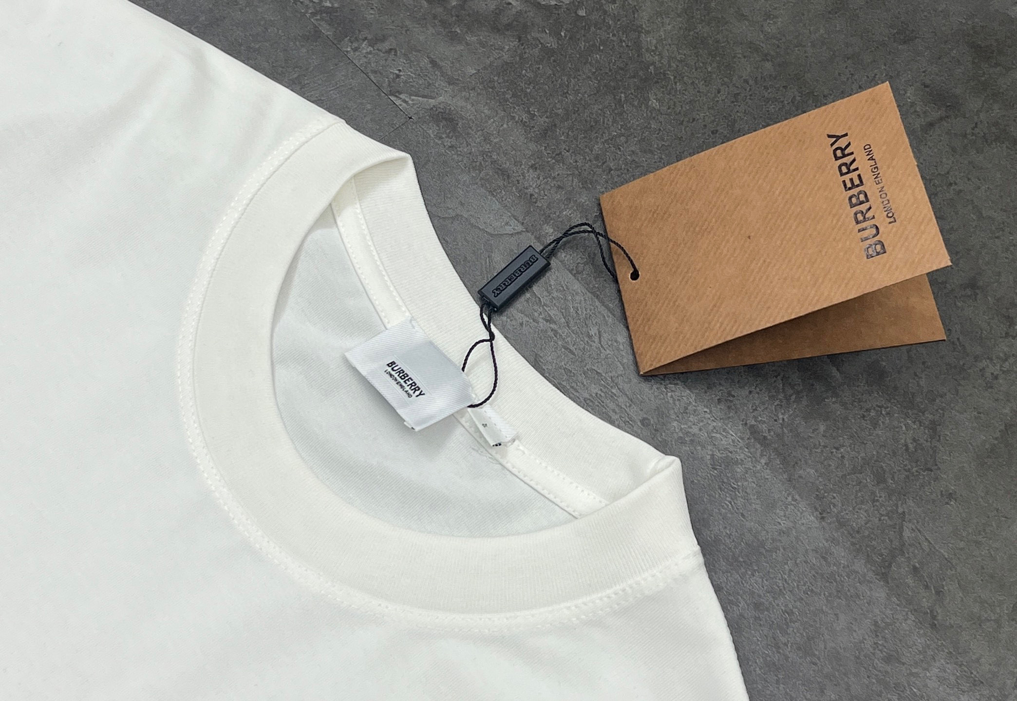 💰85
👑新款短袖上新🆕25ss夏季新品BURBERRY 🐎巴宝莉骑士tee，经典永流传，简直是时尚圈的“常青树”🌲

260g双纱面料，质感直接拉满💯  软糯又挺括，贴身穿像被云朵轻轻包裹☁️  厚度刚好，四季穿都很奈斯，不会软塌塌没型，高级感拿捏～

经典骑士图案🏇  金色印花超精致，战马奔腾的设计，自带英伦贵族气场，走在街上，回头率爆棚📸  不管是搭牛仔裤走休闲风，还是配西装裤凹轻商务造型，都能稳稳hold住，轻松拿捏各种风格切换✨

印花工艺也很绝，久洗不易脱落、开裂，经得住时间考验⌛️  就像巴宝莉的品牌魅力，历久弥新，穿个几年依旧是衣柜里的“宝藏单品”💎

喜欢经典款、追求品质的宝子，别错过！穿上它，你就是行走的时尚教科书，把高级感焊在身上～

颜色：黑色/白色
尺码：M  L  XL  2XL

M：胸围54  肩宽52   衣长70   袖长22.5
（建议身高170-173厘米）
（建议体重110-135斤）
L：胸围 56  肩宽54   衣长72  袖长23
（建议身高173-175厘米）
（建议体重135-160斤）
XL：胸围58  肩宽56  衣长74  袖长23.5
（建议身高175-180厘米）
（建议体重160-185斤）
2XL：胸围60  肩宽58  衣长76   袖长24 
（建议身高180-185厘米）
（建议体重185-210斤）
👑温馨提示:手工平铺测量，误差在1-2cm内属于正常范围
