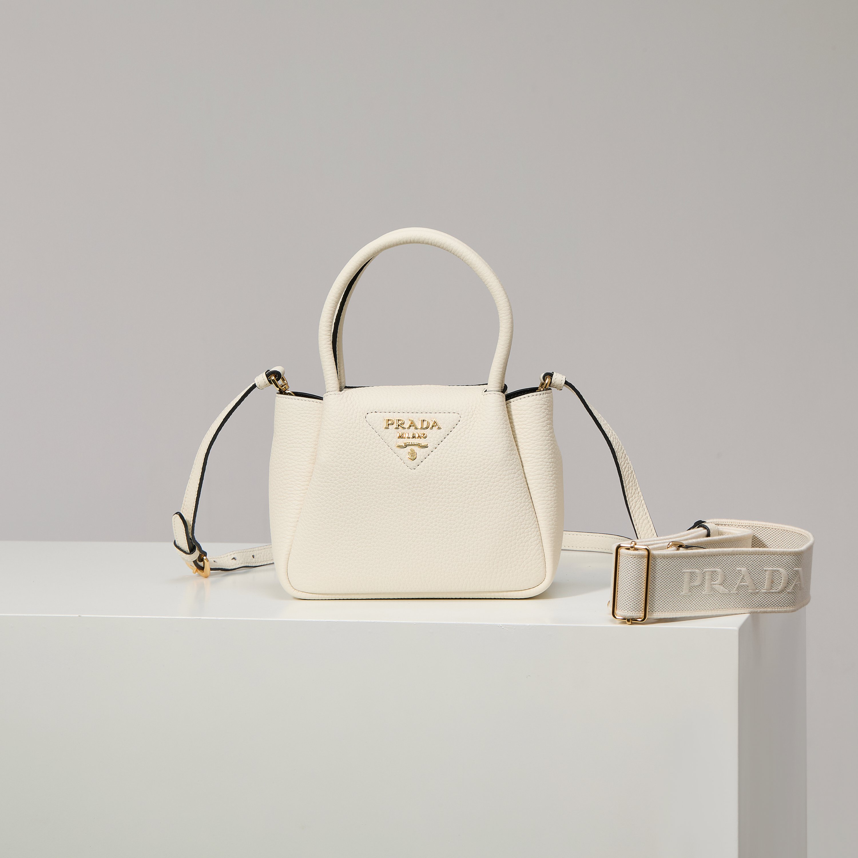 NO:602411,[Special Original] New Mini Shoulder Bag 1BA362/White/(Double Strap) from the counter has arrived. This contemporary exquisite leather handbag presents natural texture and uses reverse stitching design to create a soft and round shape. It is compact and can be carried by hand or carried on the back with a detachable shoulder strap. The shape is versatile and refined and elegant. Detachable and adjustable leather shoulder strap, length 95 cm. Maximum length 107 cm - Minimum length 56 cm - Maximum vertical length 56 cm -  Minimum drop length 35cm, metal hardware accessories, metal letter logo on the front, zipper bag opening, with 3 compartments, great texture. I fell in love with it at first sight. Ladies, hurry up and get it. Size 18*19.5*9cm, Prada [price in quantity], prada, shoulder bags19860909【特级原厂】专柜新款迷你单肩包1BA362/白色/（双肩带）到货这款当代精致皮革手袋呈现天然纹理,以反向缝线设计打造柔软圆润的造型.体量小巧,既可手提,又可配上可拆卸肩带后肩背,造型百变,精致优雅. 可拆卸可调式皮革肩带,长度95厘米.最大长度107厘米 - 最小长度56厘米 - 最大垂长56厘米 - 最小垂长35厘米,金属五金配件,正面金属字母徽标,拉链包口,配3个隔层,质感超赞 一眼就爱上了 女士们赶紧下手吧 尺寸18*19.5*9cm,普拉达【跑量价】,prada,shoulder bags,Bag