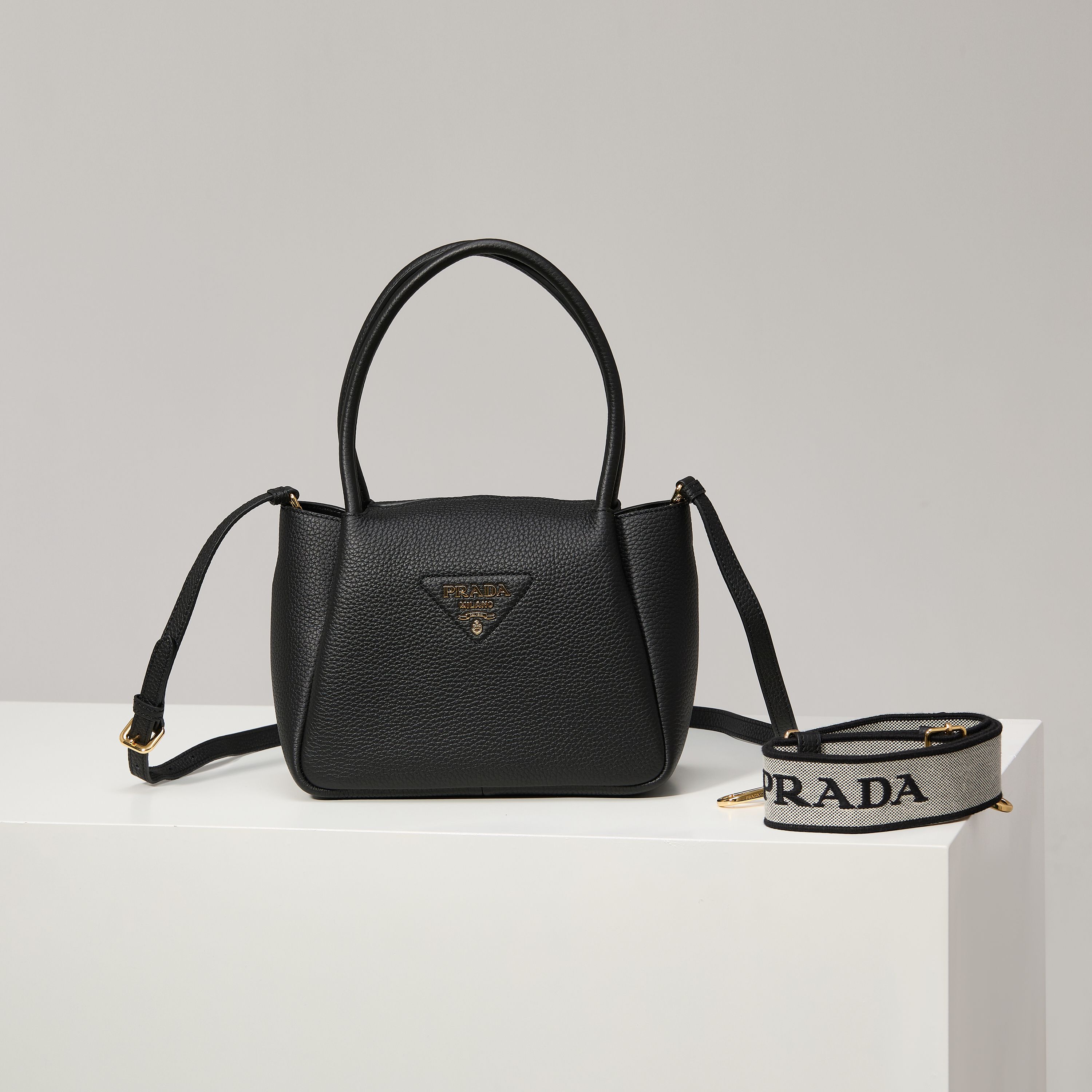 NO:602468,[Special Original] The new small shoulder bag 1BC145 gold buckle/black (double strap) from the counter has arrived. This bag is made of textured leather, with reverse stitching to outline the soft and round shape of the bag, highlighting a modern and sophisticated style. The practical style that is easy to carry or carry on the shoulder shows a versatile design concept, integrating urban elegance and sporty style. Adjustable and detachable logo-printed webbing shoulder strap, length 95 cm. Maximum length 107 cm - Minimum length 56 cm -  The maximum hanging length is 56 cm - the minimum hanging length is 35 cm, detachable and adjustable leather shoulder strap. Metal hardware accessories, metal letter logo on the front, zipper bag mouth, great texture. I fell in love with it at first sight. Ladies, hurry up and get it. Size: length 23*height 21*width 10cm, Prada [price based on quantity], prada, shoulder bags19860909【特级原厂】专柜新款小号单肩包1BC145金扣/黑色（双肩带）到货这款包袋采用纹理皮革制成,以反向缝线勾勒出包身柔软、圆润的造型,彰显现代而精致的风格.易于手提或肩背的实用风格展现百搭设计理念,融合都市优雅品味和运动风范. 可调式可拆卸徽标印花织带肩带,长度95厘米.最大长度107厘米 - 最小长度56厘米 - 最大垂长56厘米 - 最小垂长35厘米,可拆卸可调式皮革肩带.金属五金配件,正面金属字母徽标,拉链包口,质感超赞 一眼就爱上了 女士们赶紧下手吧 尺寸长23*高21*宽10cm,普拉达【跑量价】,prada,shoulder bags,Bag