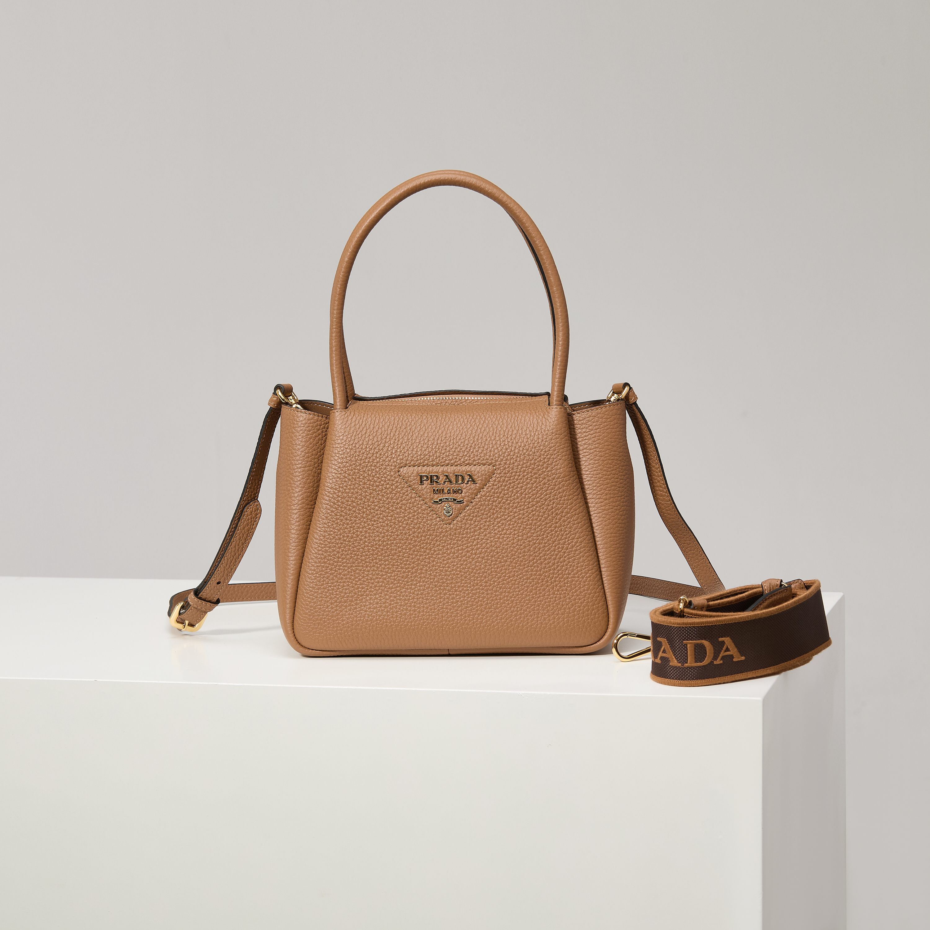 NO:602433,[Special Original] The new small shoulder bag 1BC145 gold buckle/caramel (double shoulder strap) from the counter is available. This bag is made of textured leather, with reverse stitching to outline the soft and round shape of the bag, highlighting a modern and sophisticated style. The practical style that is easy to carry or carry on the shoulder shows a versatile design concept, integrating urban elegance and sporty style. Adjustable and detachable logo-printed webbing shoulder strap, length 95 cm. Maximum length 107 cm - Minimum length 56 cm -  The maximum hanging length is 56 cm - the minimum hanging length is 35 cm, detachable and adjustable leather shoulder strap. Metal hardware accessories, metal letter logo on the front, zipper bag mouth, great texture. I fell in love with it at first sight. Ladies, hurry up and get it. Size: length 23*height 21*width 10cm, Prada [price based on quantity], prada, shoulder bags19860909【特级原厂】专柜新款小号单肩包1BC145金扣/焦糖（双肩带）到货这款包袋采用纹理皮革制成,以反向缝线勾勒出包身柔软、圆润的造型,彰显现代而精致的风格.易于手提或肩背的实用风格展现百搭设计理念,融合都市优雅品味和运动风范. 可调式可拆卸徽标印花织带肩带,长度95厘米.最大长度107厘米 - 最小长度56厘米 - 最大垂长56厘米 - 最小垂长35厘米,可拆卸可调式皮革肩带.金属五金配件,正面金属字母徽标,拉链包口,质感超赞 一眼就爱上了 女士们赶紧下手吧 尺寸长23*高21*宽10cm,普拉达【跑量价】,prada,shoulder bags,Bag