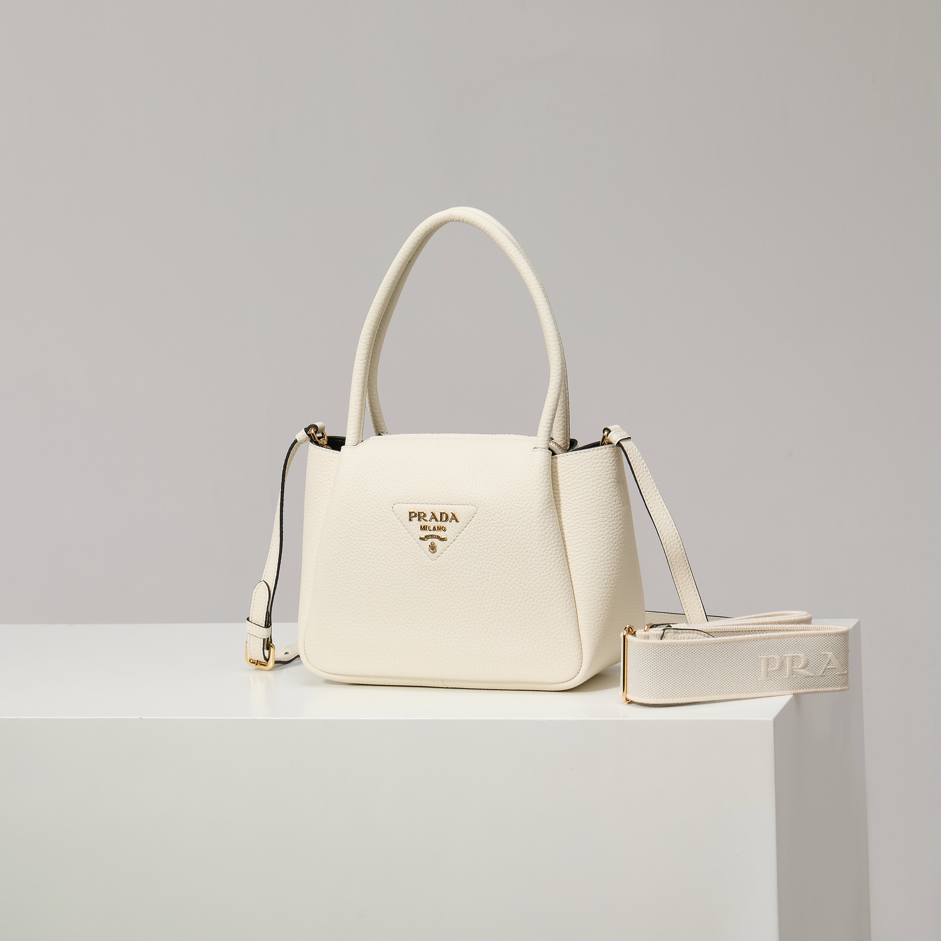 NO:602453,[Special Original] New Small Shoulder Bag 1BC145 Gold Buckle/White (Double Strap) from the counter has arrived. This bag is made of textured leather, with reverse stitching to outline a soft and rounded shape, highlighting a modern and sophisticated style. The practical style that is easy to carry or carry on the shoulder shows a versatile design concept, integrating urban elegance and sporty style. Adjustable and detachable logo-printed webbing shoulder strap, length 95 cm. Maximum length 107 cm - Minimum length 56 cm -  The maximum hanging length is 56 cm - the minimum hanging length is 35 cm, detachable and adjustable leather shoulder strap. Metal hardware accessories, metal letter logo on the front, zipper bag mouth, great texture. I fell in love with it at first sight. Ladies, hurry up and get it. Size: length 23*height 21*width 10cm, Prada [price based on quantity], prada, shoulder bags19860909【特级原厂】专柜新款小号单肩包1BC145金扣/白色（双肩带）到货这款包袋采用纹理皮革制成,以反向缝线勾勒出包身柔软、圆润的造型,彰显现代而精致的风格.易于手提或肩背的实用风格展现百搭设计理念,融合都市优雅品味和运动风范. 可调式可拆卸徽标印花织带肩带,长度95厘米.最大长度107厘米 - 最小长度56厘米 - 最大垂长56厘米 - 最小垂长35厘米,可拆卸可调式皮革肩带.金属五金配件,正面金属字母徽标,拉链包口,质感超赞 一眼就爱上了 女士们赶紧下手吧 尺寸长23*高21*宽10cm,普拉达【跑量价】,prada,shoulder bags,Bag