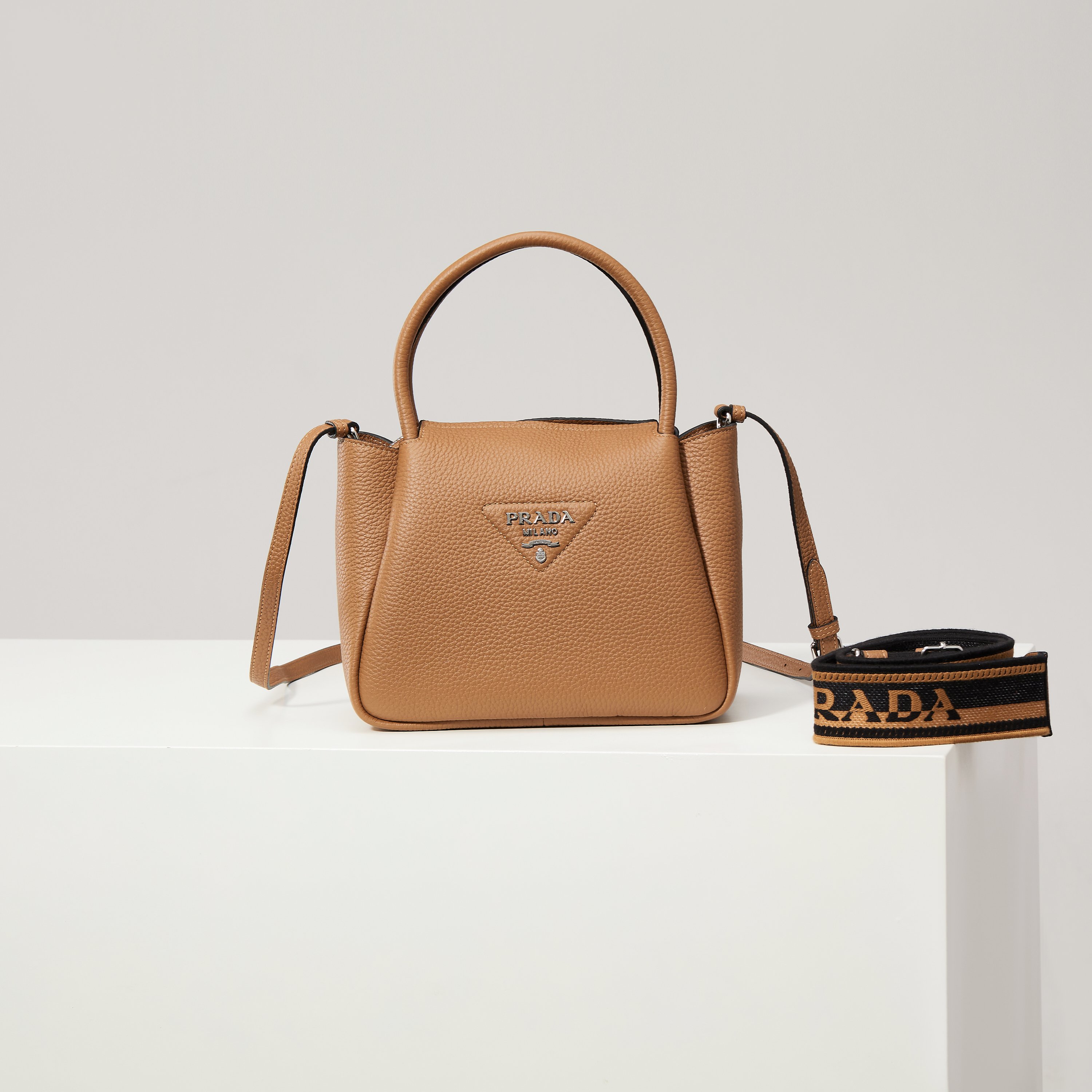 NO:602434,[Special Original] New Small Shoulder Bag 1BC145 Silver Buckle/Caramel (Double Shoulder Strap) is available at the counter. This bag is made of textured leather, with reverse stitching to outline a soft and rounded shape, highlighting a modern and sophisticated style. The practical style that is easy to carry or carry on the shoulder shows a versatile design concept, integrating urban elegance and sporty style. Adjustable and detachable logo-printed webbing shoulder strap, length 95 cm. Maximum length 107 cm - Minimum length 56 cm -  The maximum hanging length is 56 cm - the minimum hanging length is 35 cm, detachable and adjustable leather shoulder strap. Metal hardware accessories, metal letter logo on the front, zipper bag mouth, great texture. I fell in love with it at first sight. Ladies, hurry up and get it. Size: length 23*height 21*width 10cm, Prada [price based on quantity], prada, shoulder bags19860909【特级原厂】专柜新款小号单肩包1BC145银扣/焦糖（双肩带）到货这款包袋采用纹理皮革制成,以反向缝线勾勒出包身柔软、圆润的造型,彰显现代而精致的风格.易于手提或肩背的实用风格展现百搭设计理念,融合都市优雅品味和运动风范. 可调式可拆卸徽标印花织带肩带,长度95厘米.最大长度107厘米 - 最小长度56厘米 - 最大垂长56厘米 - 最小垂长35厘米,可拆卸可调式皮革肩带.金属五金配件,正面金属字母徽标,拉链包口,质感超赞 一眼就爱上了 女士们赶紧下手吧 尺寸长23*高21*宽10cm,普拉达【跑量价】,prada,shoulder bags,Bag