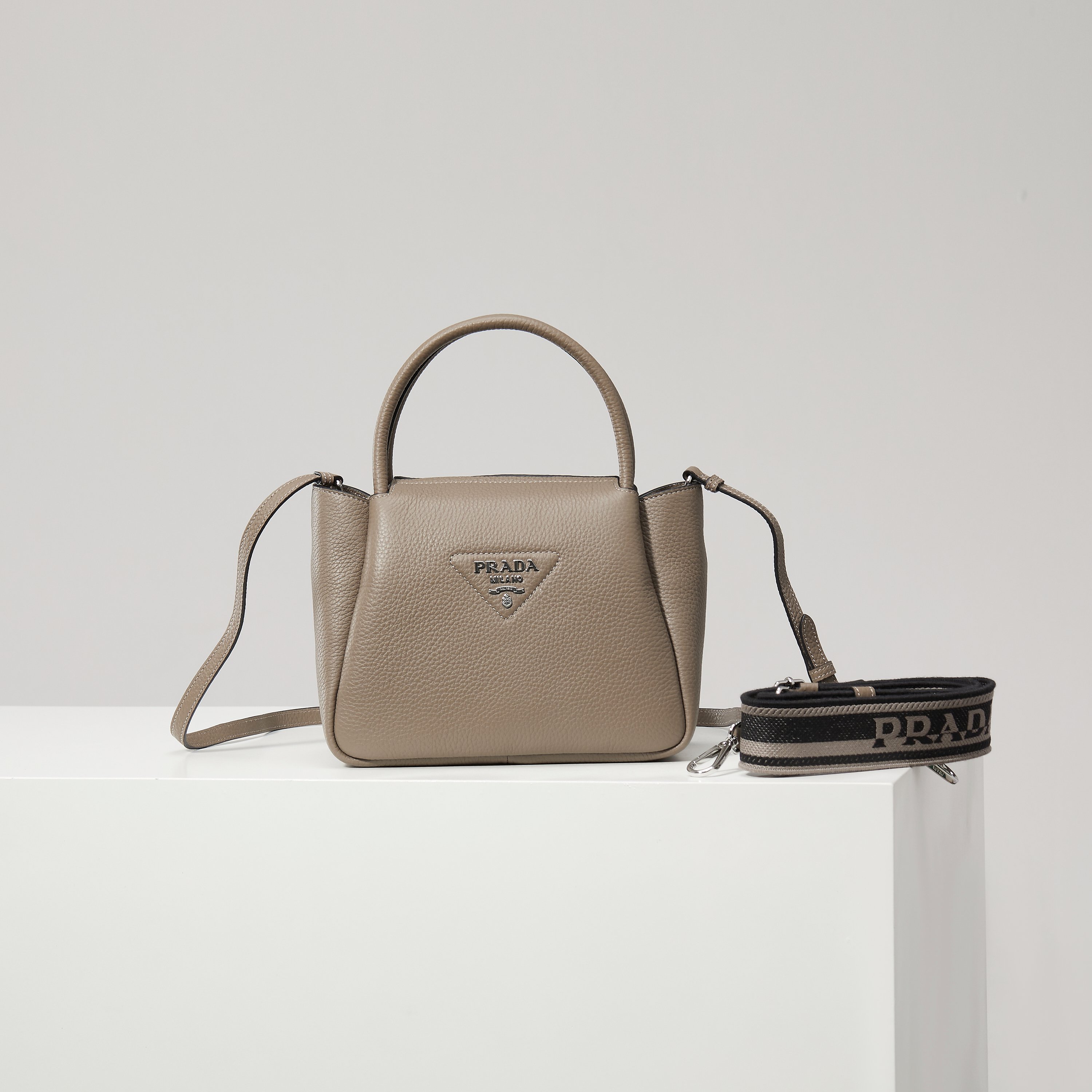 NO:602454,[Special Original] New Small Shoulder Bag 1BC145 Silver Buckle/Gray (Double Strap) from the counter is available. This bag is made of textured leather, with reverse stitching to outline a soft and rounded shape, highlighting a modern and sophisticated style. The practical style that is easy to carry or carry on the shoulder shows a versatile design concept, integrating urban elegance and sporty style. Adjustable and detachable logo-printed webbing shoulder strap, length 95 cm. Maximum length 107 cm - Minimum length 56 cm -  The maximum hanging length is 56 cm - the minimum hanging length is 35 cm, detachable and adjustable leather shoulder strap. Metal hardware accessories, metal letter logo on the front, zipper bag mouth, great texture. I fell in love with it at first sight. Ladies, hurry up and get it. Size: length 23*height 21*width 10cm, Prada [price based on quantity], prada, shoulder bags19860909【特级原厂】专柜新款小号单肩包1BC145银扣/灰色（双肩带）到货这款包袋采用纹理皮革制成,以反向缝线勾勒出包身柔软、圆润的造型,彰显现代而精致的风格.易于手提或肩背的实用风格展现百搭设计理念,融合都市优雅品味和运动风范. 可调式可拆卸徽标印花织带肩带,长度95厘米.最大长度107厘米 - 最小长度56厘米 - 最大垂长56厘米 - 最小垂长35厘米,可拆卸可调式皮革肩带.金属五金配件,正面金属字母徽标,拉链包口,质感超赞 一眼就爱上了 女士们赶紧下手吧 尺寸长23*高21*宽10cm,普拉达【跑量价】,prada,shoulder bags,Bag