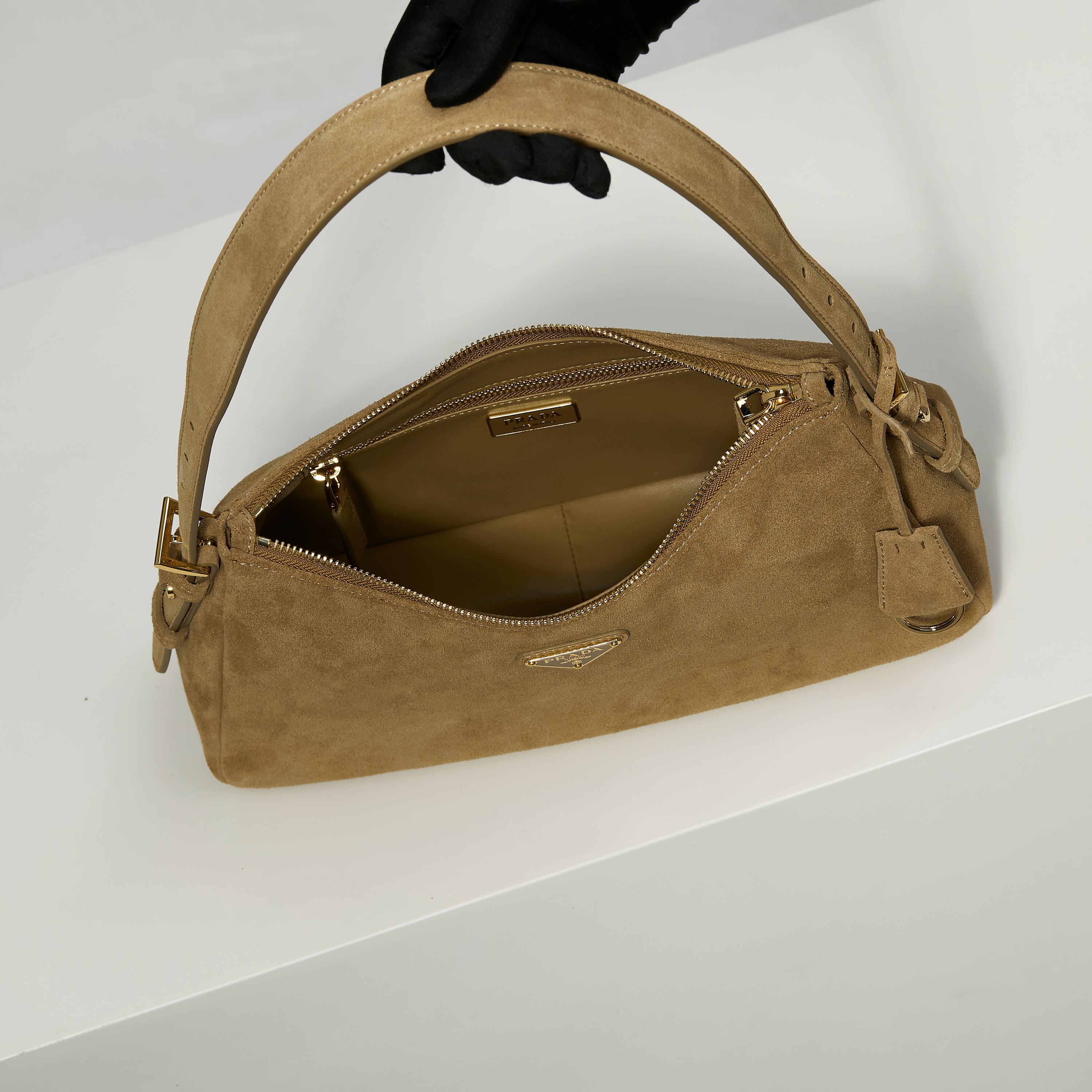 p710。 【特级原厂】🎉🎉🎉1BC229/肉桂色/磨砂皮🔥🔥🔥Prada Etude小号绒面皮革 
2025秋冬系列广告大片中的全新Prada Aim&eacute;e手袋造型精致优雅，设计灵感源自1990年代的极简主义风格。采用柔软的绒面牛皮革打造，让人不由得想将其拿在手上，亦可轻松单肩背。&middot;搭配可调节提手。最小垂长38厘米-最大垂长28厘米
●可拆卸钥匙扣
&middot;金属五金配件
&middot;正面涂珐琅三角形金属徽标
&middot;拉链开合
&middot;内里配2个内袋，包括1个拉链袋
宽:31cm&times;高:18cm&times;长:10cm