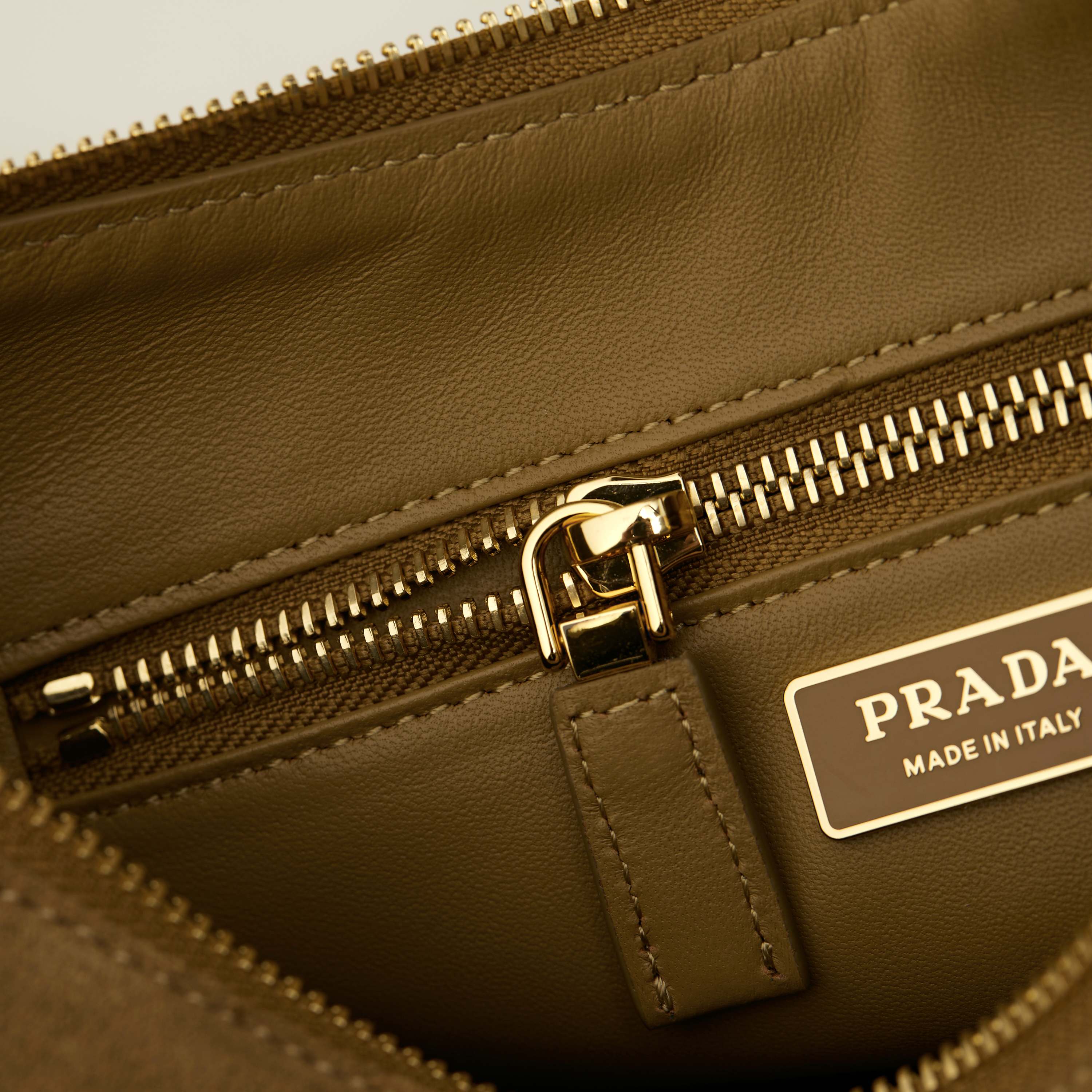 p710。 【特级原厂】🎉🎉🎉1BC229/肉桂色/磨砂皮🔥🔥🔥Prada Etude小号绒面皮革 
2025秋冬系列广告大片中的全新Prada Aim&eacute;e手袋造型精致优雅，设计灵感源自1990年代的极简主义风格。采用柔软的绒面牛皮革打造，让人不由得想将其拿在手上，亦可轻松单肩背。&middot;搭配可调节提手。最小垂长38厘米-最大垂长28厘米
●可拆卸钥匙扣
&middot;金属五金配件
&middot;正面涂珐琅三角形金属徽标
&middot;拉链开合
&middot;内里配2个内袋，包括1个拉链袋
宽:31cm&times;高:18cm&times;长:10cm