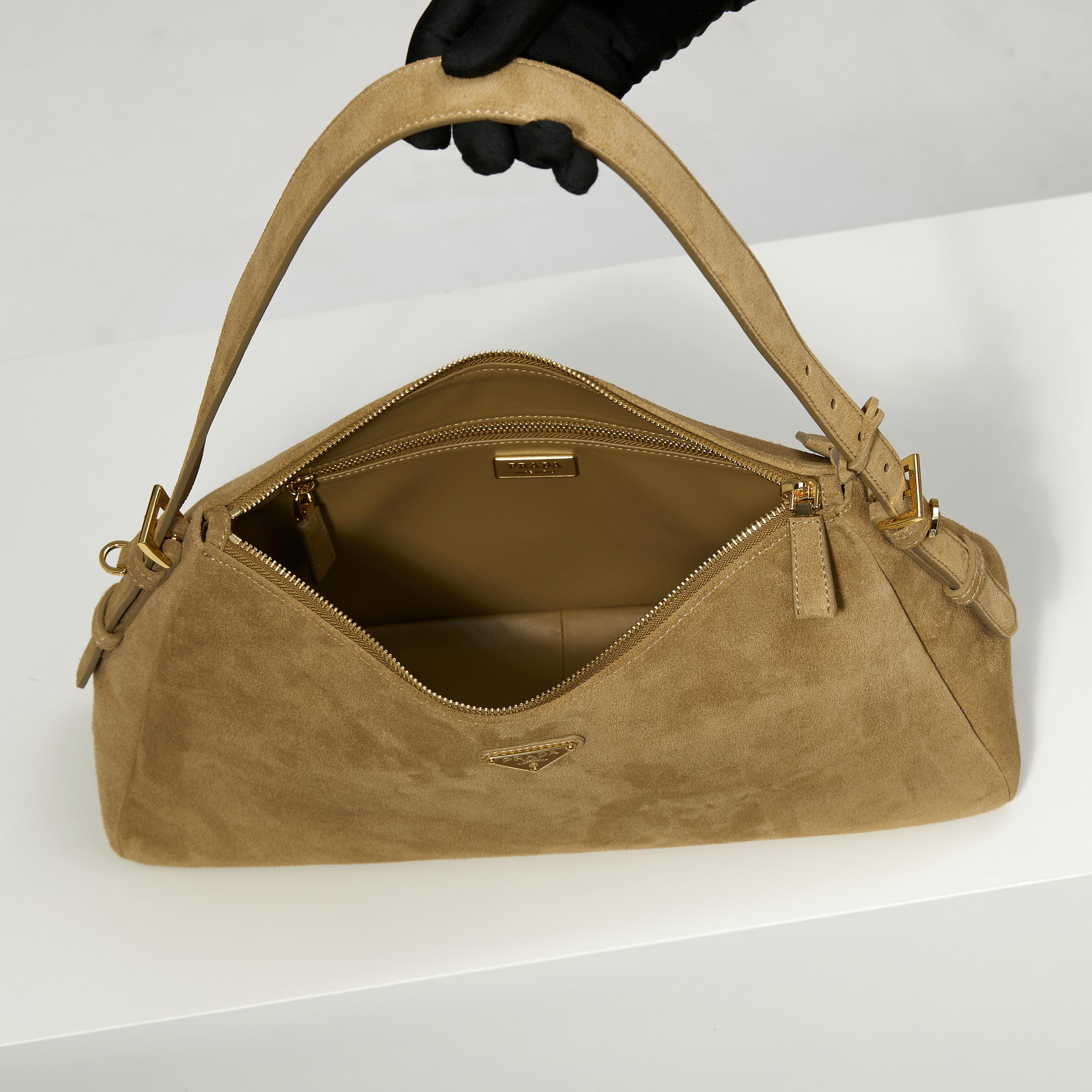 p760。 【特级原厂】🎉🎉🎉1BC228/肉桂色/磨砂皮🔥🔥🔥Prada Etude大号绒面皮革
2025秋冬系列广告大片中的全新Prada Aimee手袋从精致优雅的1990年代极简风格中汲取灵感，Hobo款型融合当代时尚线条，搭配档案库细节设计。采用柔软的绒面牛皮革打造，将背包时的自然动作融入设计考量，可肩背或斜挎。
&bull; 带手提柄
&bull;可拆卸钥匙扣
&bull;金属五金配件
&bull; 涂珐琅三角形金属徽标
&bull;拉链开合
&bull;带内里配2个口袋，包括1个拉链袋
宽39cm&times;高23cm&times;长12厘米