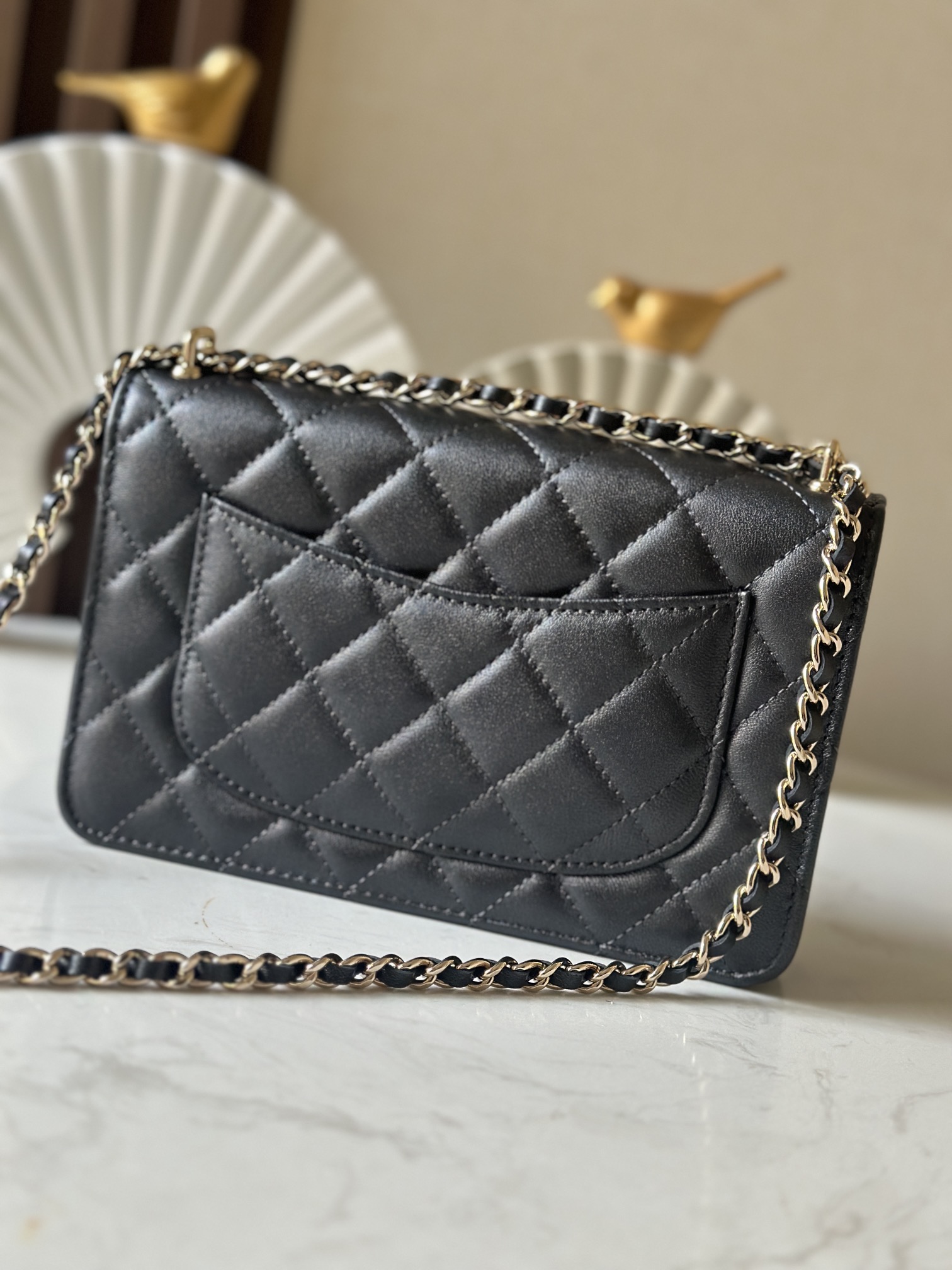 p670。chane12025春夏
chanel 太懂少女心!2025年春夏的轻巧俏
皮又精致，采用珠面小羊皮，搭配经典的菱格纹和金色 clogo。手袋上还有一个粉色心形，搭配金色链条，让人一见倾心，入坑!还可
以侧背或肩背，容量也不错，纸巾都可以放进去，通勤日常都ok
款号：66051 黑色
尺寸:19.5*13*3.5
