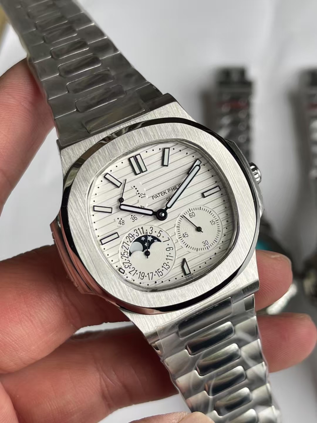 NO:602108,Patek Philippe Nautilus 5712/1A-001 multi-function watch combines classic aesthetics with an ultra-thin movement that brings together the best of the past!  Three-stage dial design, kinetic energy storage display in the upper left corner, calendar and moon phase windows in the lower left corner, and precise second hand in the lower right corner [Case] The size of the watch is 40 mm. The pillow-shaped case, which is the same as the original product, uses a combination of front brushing and side polishing. It has a clear sense of layering and full texture. It shows exquisite craftsmanship. [Strap] It is made with the original strap one to one. The central polished part of each strap can show the shape of a diamond, showing a high-end texture.  Date, true kinetic energy, true moon phase function.,, patek philippe19860909百达翡丽鹦鹉螺5712/1A-001多功能腕表,融合经典美学,超薄机芯 荟萃以往精华！三段式表盘设计,左上角动能储存显示,左下角日历和月相窗口,右下角精准秒针【表壳】腕表尺寸40毫米,同正品一致的枕型表壳采用正面拉丝,侧面抛光的两种工艺组合,层次感分明,质感十足.尽显精湛工艺.【表带】采用原装表带一比一量身打造,每节表带的中央抛光部位,都能呈现钻石的形状,尽显高级质感. 日期,真动能,真月相功能.,,patek philippe,Watch