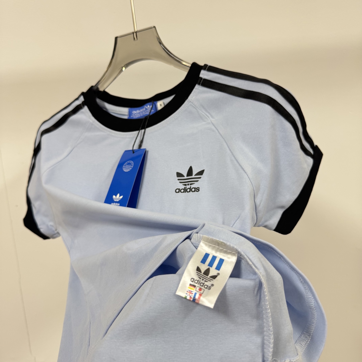 8615# P78 （三叶草女款大爆款）
Adidas 阿迪达斯 三叶草 经典款 简约经典Logo 三道杠女款短袖T恤
❗本款为女款噢 胸弟们🖐🏻定

🖤强力推荐 店主自留款！大货大货出来啦！胸弟集美们给我冲它！

🔹 高品螺纹：
衣服好不好，懂行的老板都看螺纹！
我家同步官网，螺纹是近两年巨火爆的小高领设计，双层线包边设计，客供对色螺纹领口，视觉非常显高级！

🔹辅料：
从吊牌到主麦再到水洗，我家全部大厂统一定制，同步官网，材质都是代工一模一样！
#我家水洗标有带二维码！

⚠️强调：咱家衣服面料细节胸弟集美们可以回去拿别家同款随意对比!! 区别市面低版本Lj通货!! 那种200克薄的像纸的、还没穿就起球的、穿上一出汗就黏的、光还没照就薄的透的，别来沾边~
‼️我们不砸价不压价，用心供货只做高版本!!! 胸弟集美们一定要看清楚我家细节，我家图片均为店主本人实拍❤️收到后可以核对质量细节，避免被混发，就算不太懂的集美们，那咱们花小钱买一件穿几年和穿几天的区别我相信都是知道哒😂

◎ Size：S M L XL

◎ Color：黑色 / 天蓝色 / 白色

❍#阿迪达斯
愿景：我们的运动激情让世界变得更和平；
态度：Impossible　is　Nothing.没有不可能；adidas is all in.全倾全力；
使命：成为领导世界的运动品牌；
品牌核心价值：诚实可信、负责守信、鼓舞人心；发展创新、诚挚坦率、富有经验。
大中华区原则：Lead（积极主动）、Tell the Truth（真实坦诚）、Be Accountable（承担责任）、 Simplify（简洁明了）、Work Together（齐心协力）、Have Fun（享受快乐）。