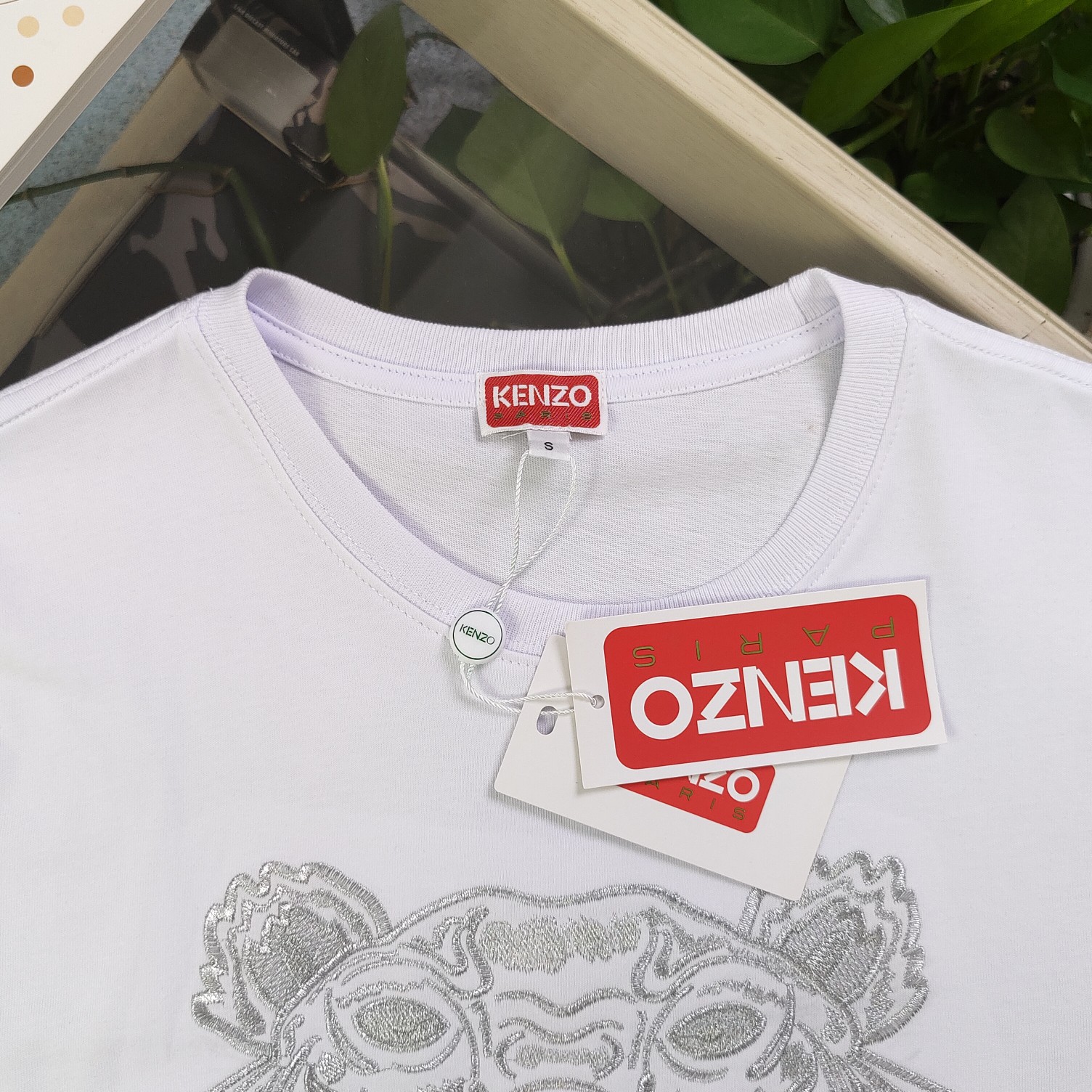 💰90
【款号：Su718】高版本
2025新款KENZO高田贤三刺绣老虎头图案logo绣花休闲情侣短袖T恤，简单整洁的配色，吸睛且高端大气，胸前几十万针精工刺绣，依然保持一丝不苟的严谨态度，给您高端品质，采用最受欢迎的丝光棉精棉面料，优质透气，舒适凉爽。内里刺绣处，网纱处理，亲肤舒适，男女同款！
颜色：白色 黑色
尺码：S～XL
    肩宽 胸围 衣长
S    42    100   65
M    44   104   67
L    46   108   69
XL  48    112   71
（注：手工测量，误差1-2cm）