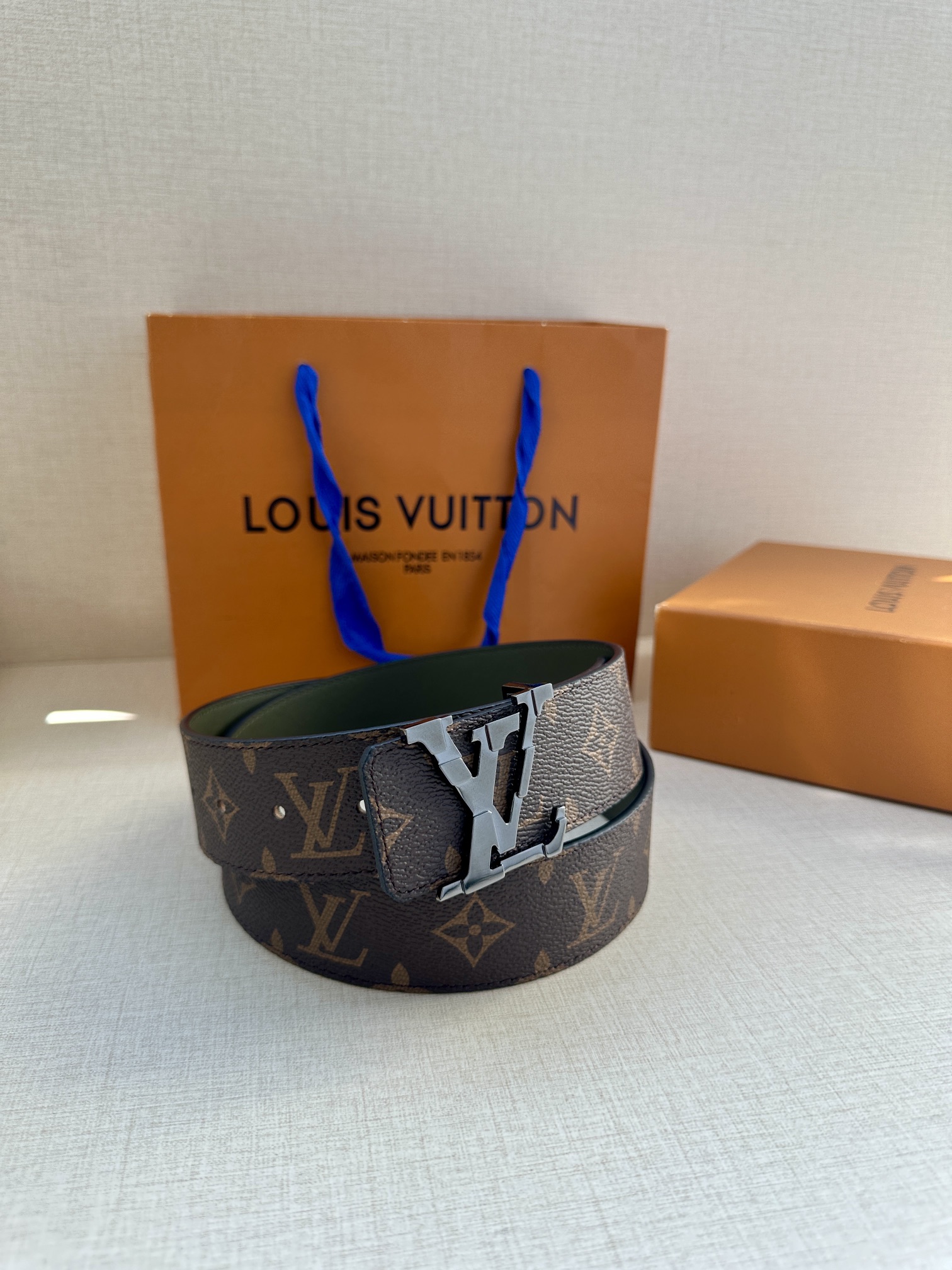 本款4.0宽LVInitiales双面腰带拼合经典Monogram帆布和素色皮革搭配中央LV字母搭扣为路