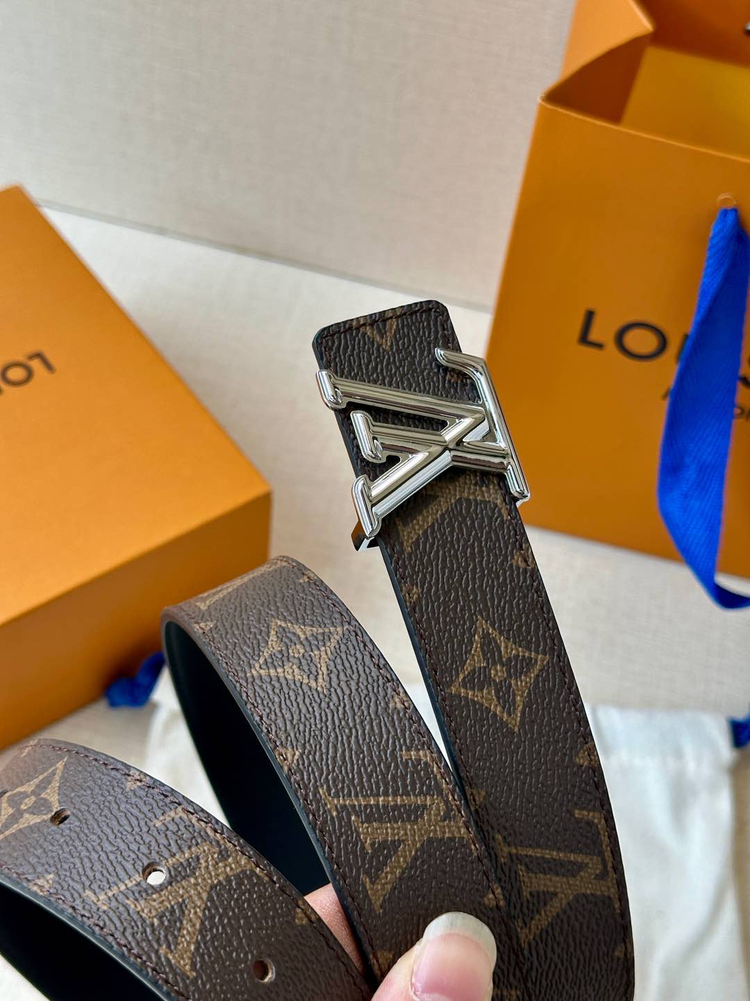  本款3.0宽 LV Initiales 双面腰带拼接光滑牛皮革和标志性 Monogram 帆布，搭配抛