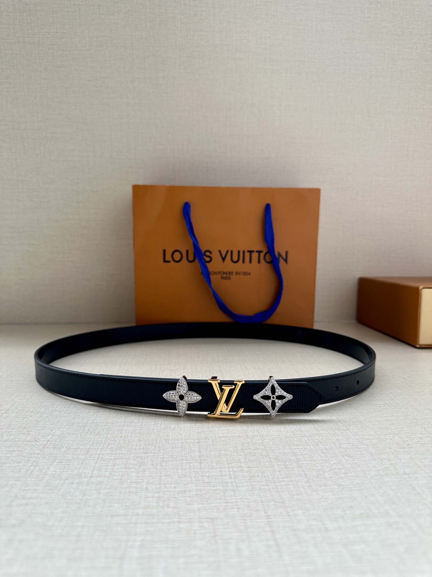  2.0宽 LV Trio 双面腰带拼合细腻牛皮革和 Monogram 帆布，为中央金属搭扣聚焦 LV 