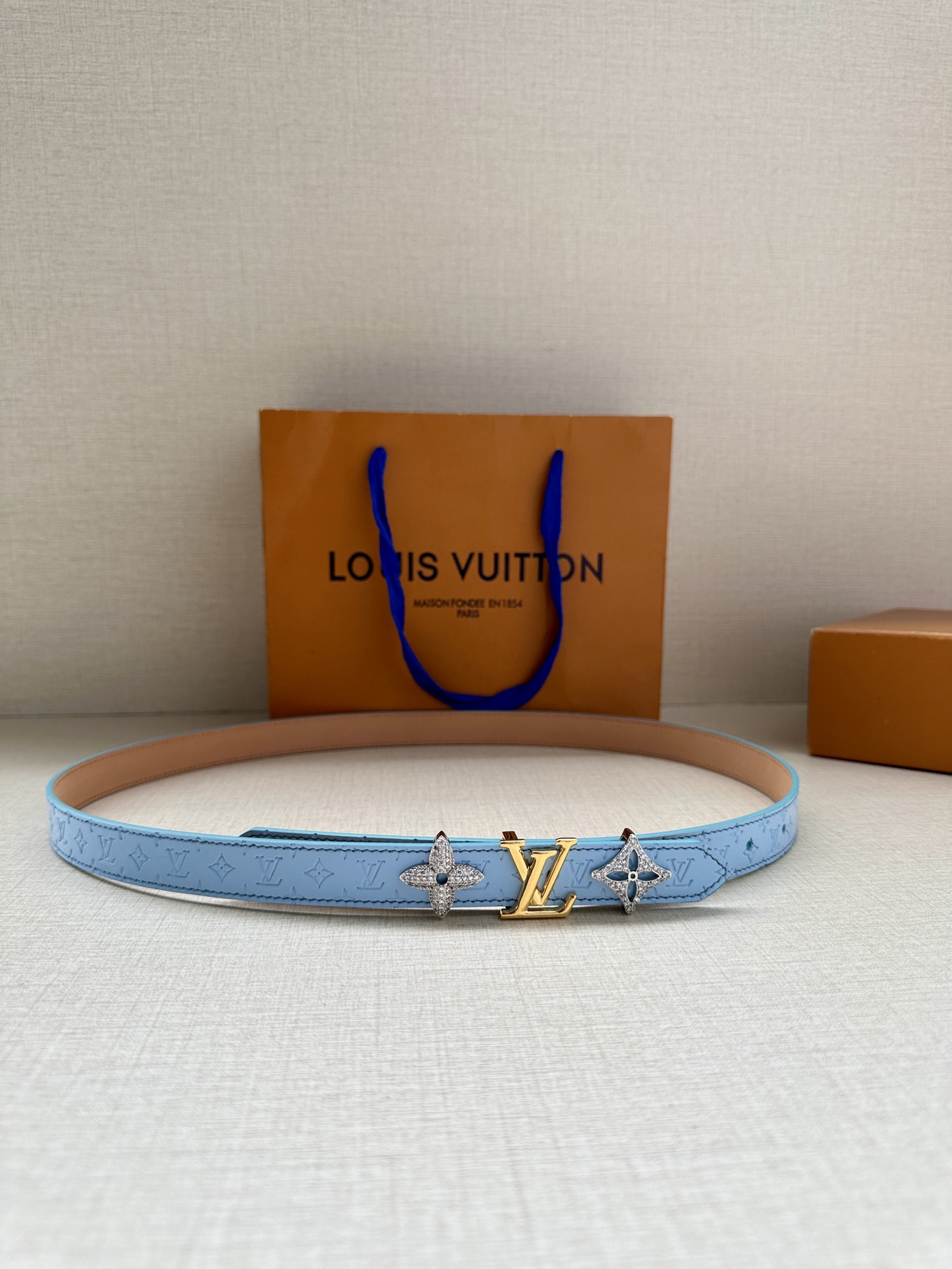  2.0宽 LV Trio 双面腰带拼合细腻牛皮革和 Monogram 帆布，为中央金属搭扣聚焦 LV 