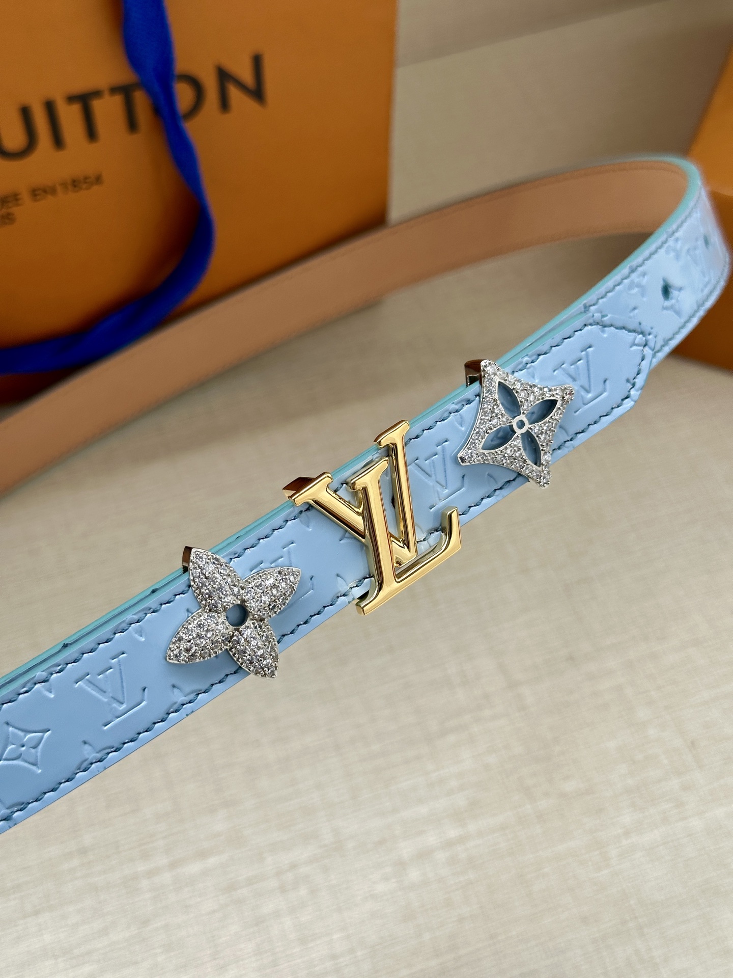  2.0宽 LV Trio 双面腰带拼合细腻牛皮革和 Monogram 帆布，为中央金属搭扣聚焦 LV 