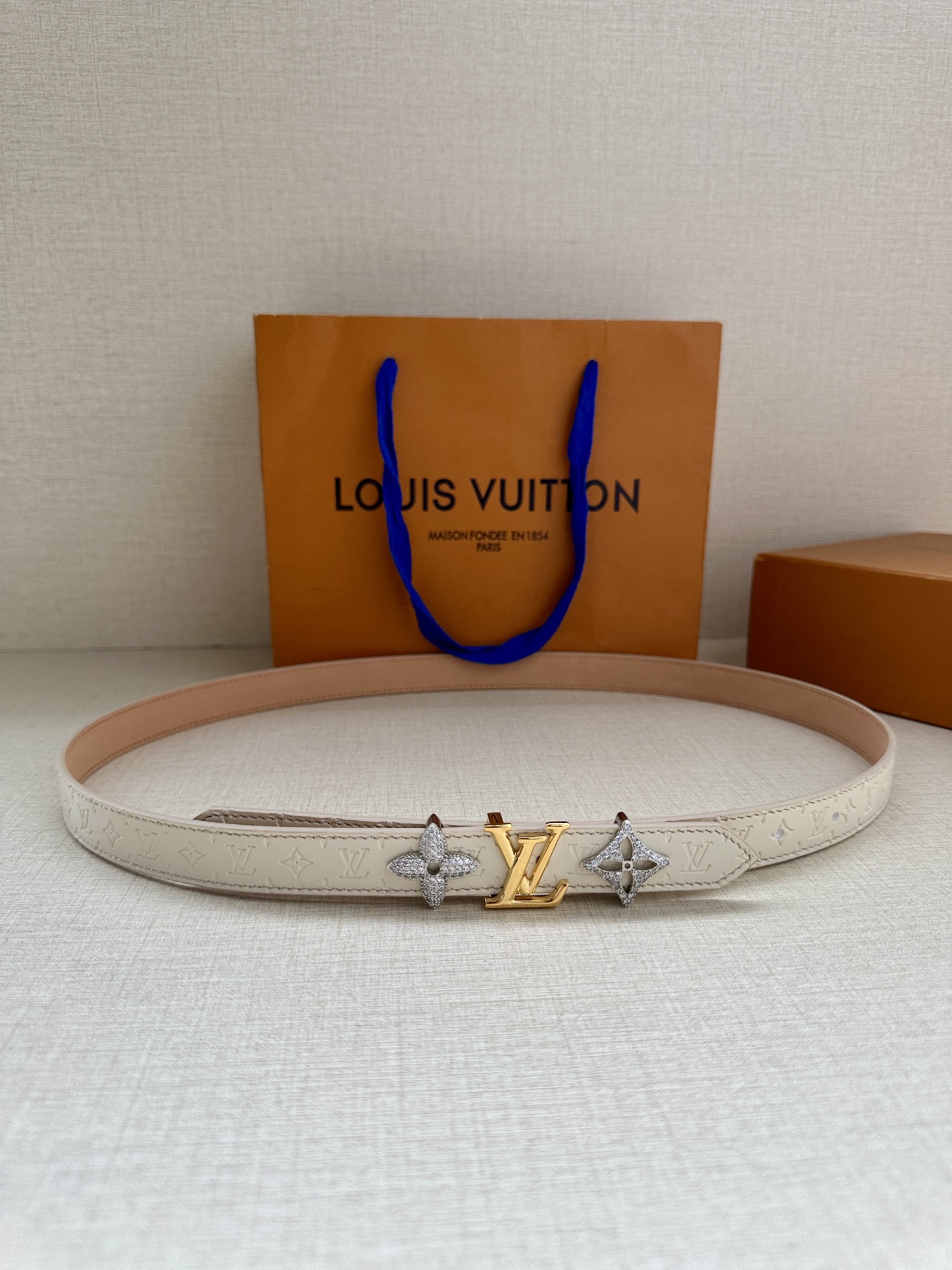  2.0宽 LV Trio 双面腰带拼合细腻牛皮革和 Monogram 帆布，为中央金属搭扣聚焦 LV 