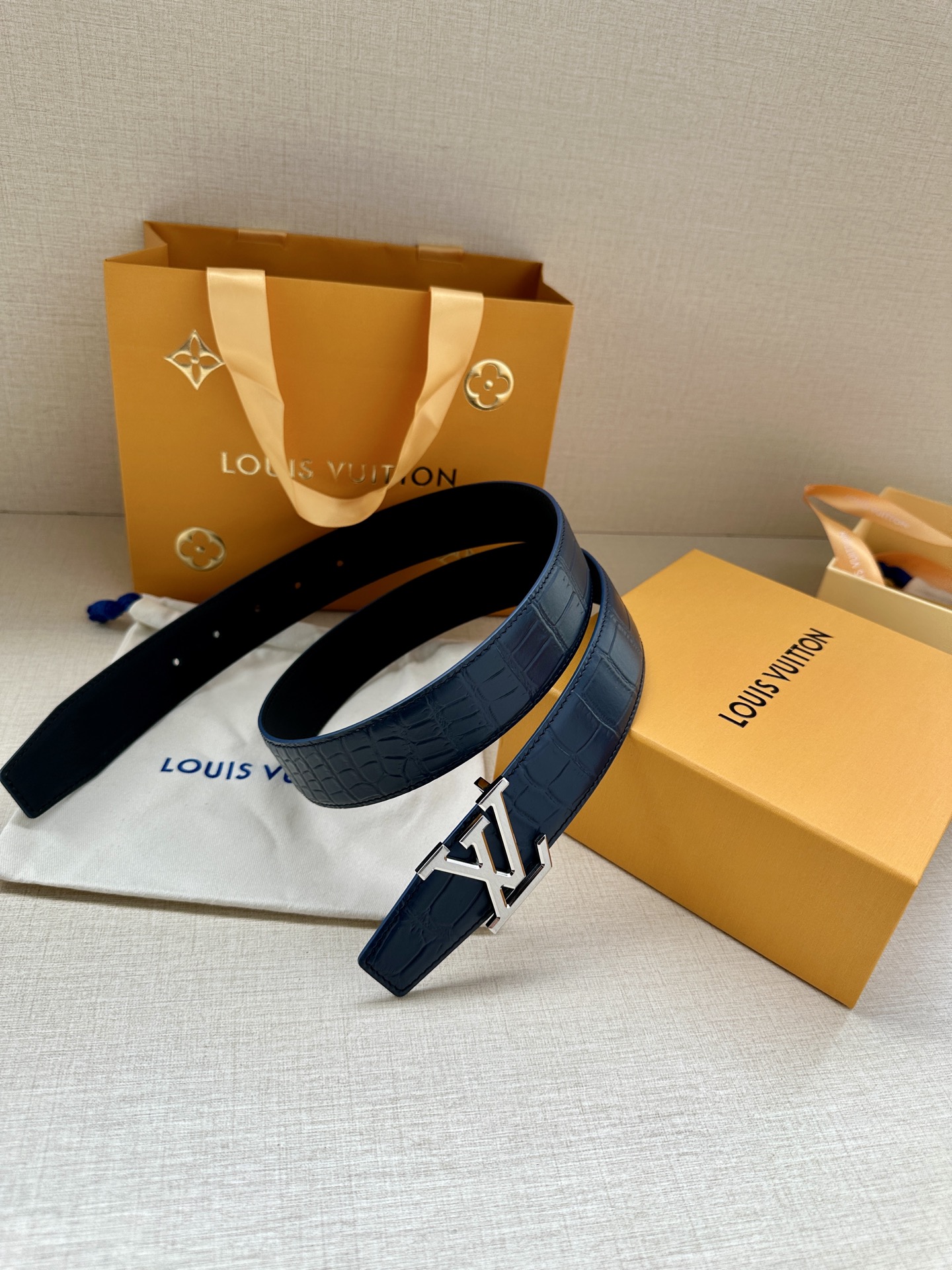 3.4宽 本款 LV Heritage 双面腰带以压鳄鱼皮革和光滑皮革呈现纹理之间的瞩目对比，搭配金属搭