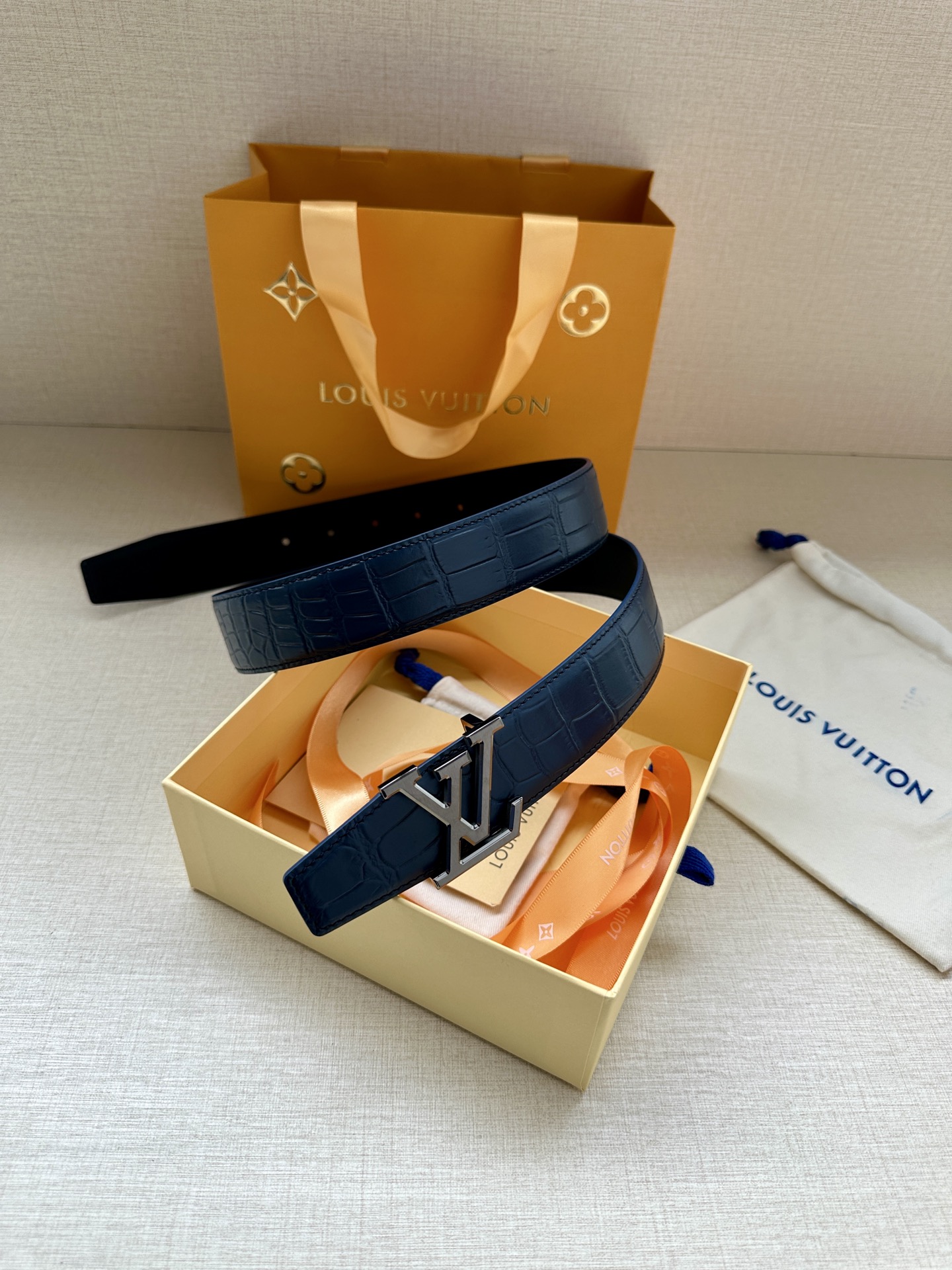 3.4宽 本款 LV Heritage 双面腰带以压鳄鱼皮革和光滑皮革呈现纹理之间的瞩目对比，搭配金属搭