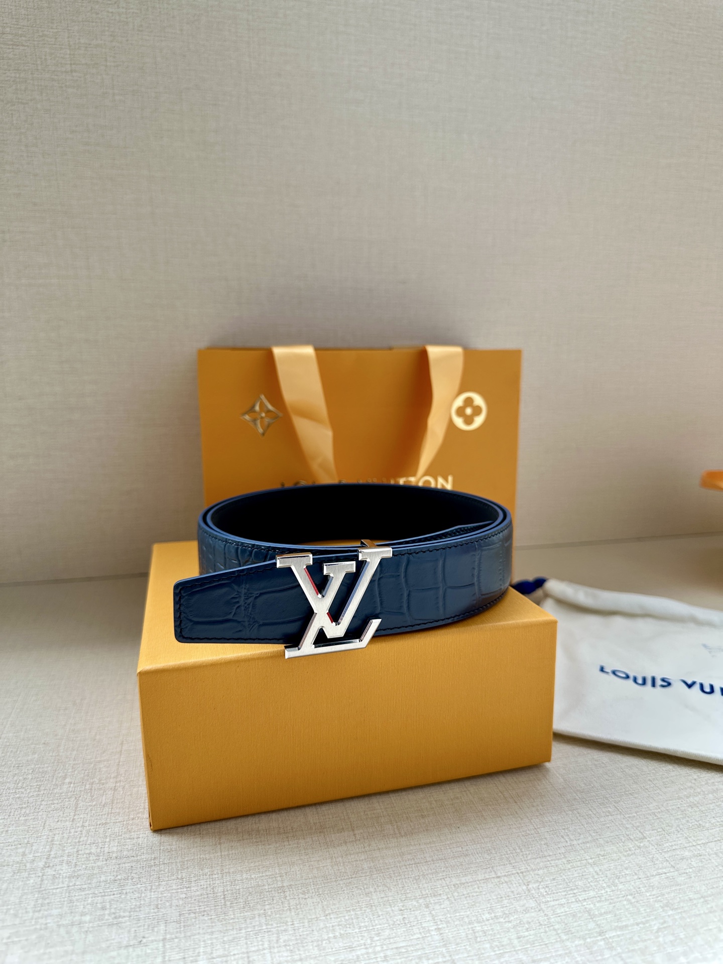 3.4宽 本款 LV Heritage 双面腰带以压鳄鱼皮革和光滑皮革呈现纹理之间的瞩目对比，搭配金属搭