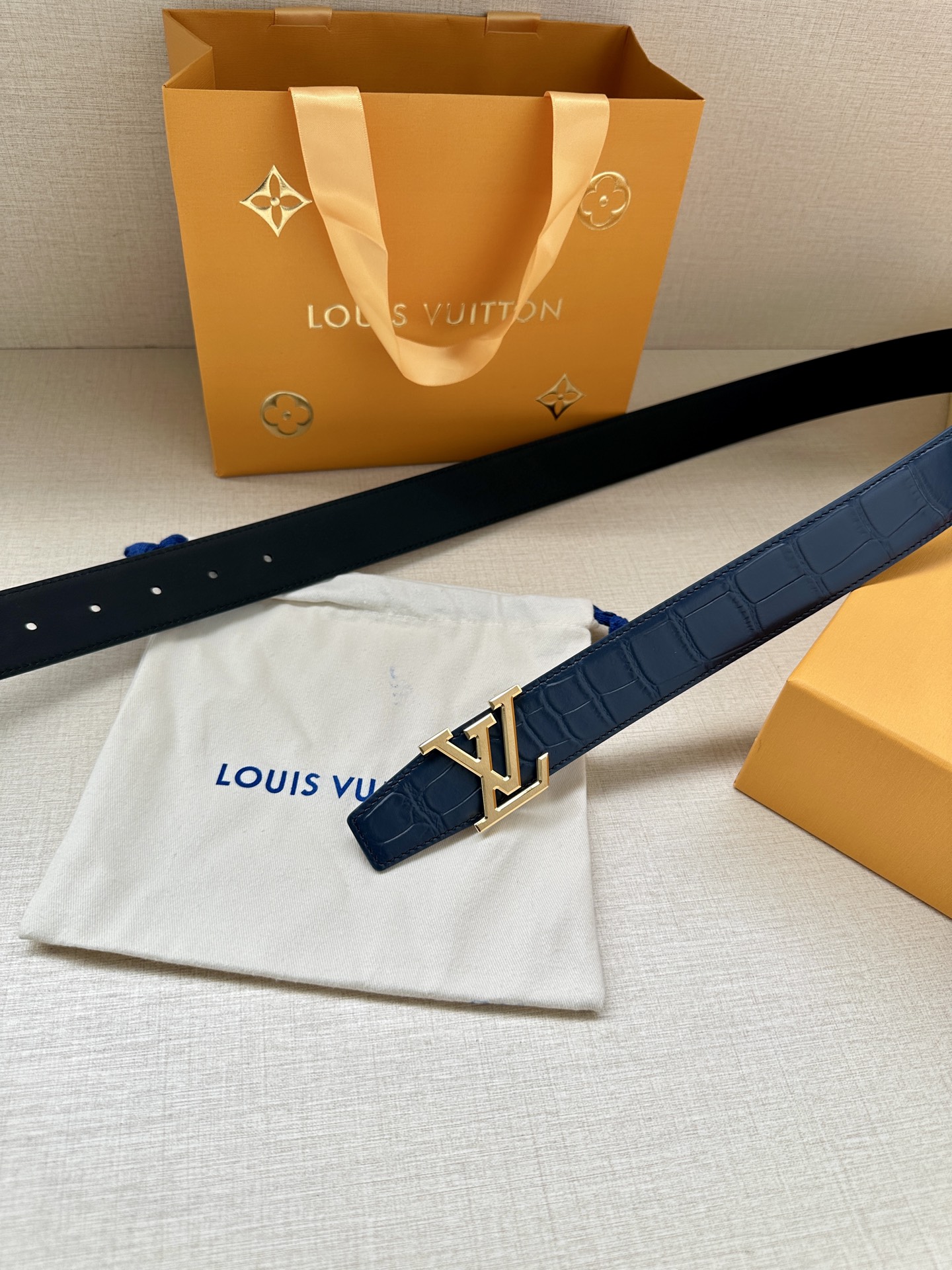 3.4宽 本款 LV Heritage 双面腰带以压鳄鱼皮革和光滑皮革呈现纹理之间的瞩目对比，搭配金属搭