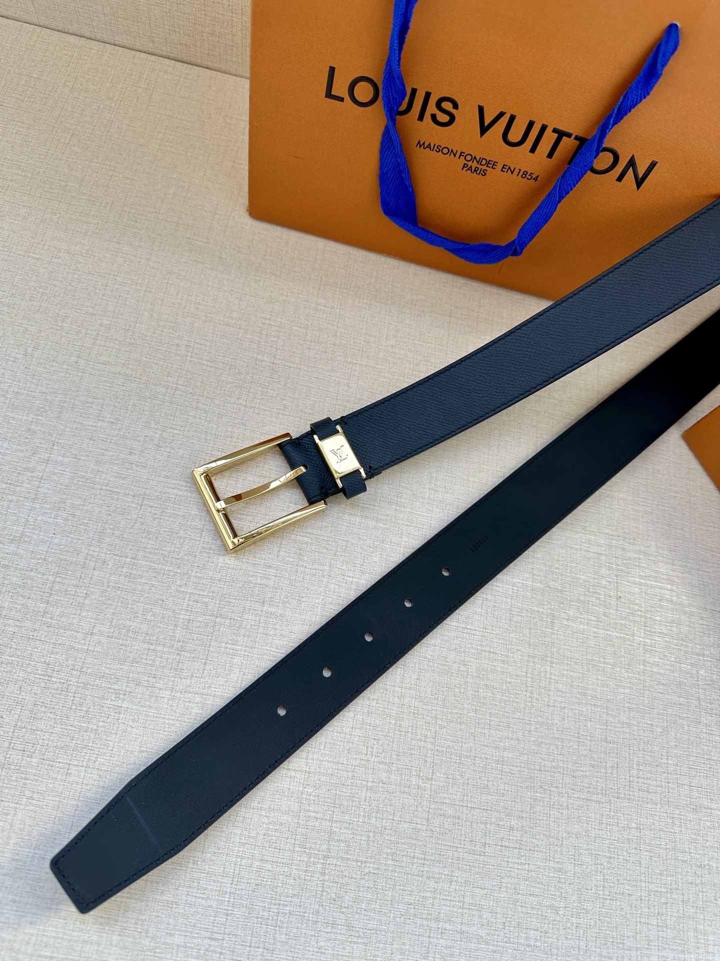  本款 LV City Pin 腰带以深邃 Taïga 皮革构筑纤细轮廓，传递简约美学。金属塑造 LV 