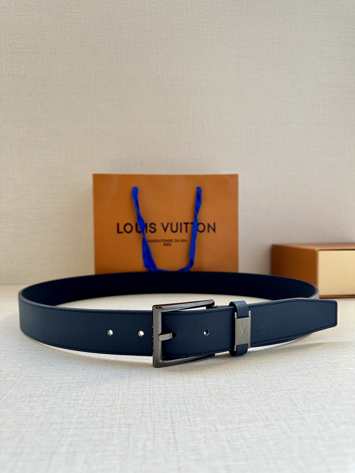  本款 LV City Pin 腰带以深邃 Taïga 皮革构筑纤细轮廓，传递简约美学。金属塑造 LV 
