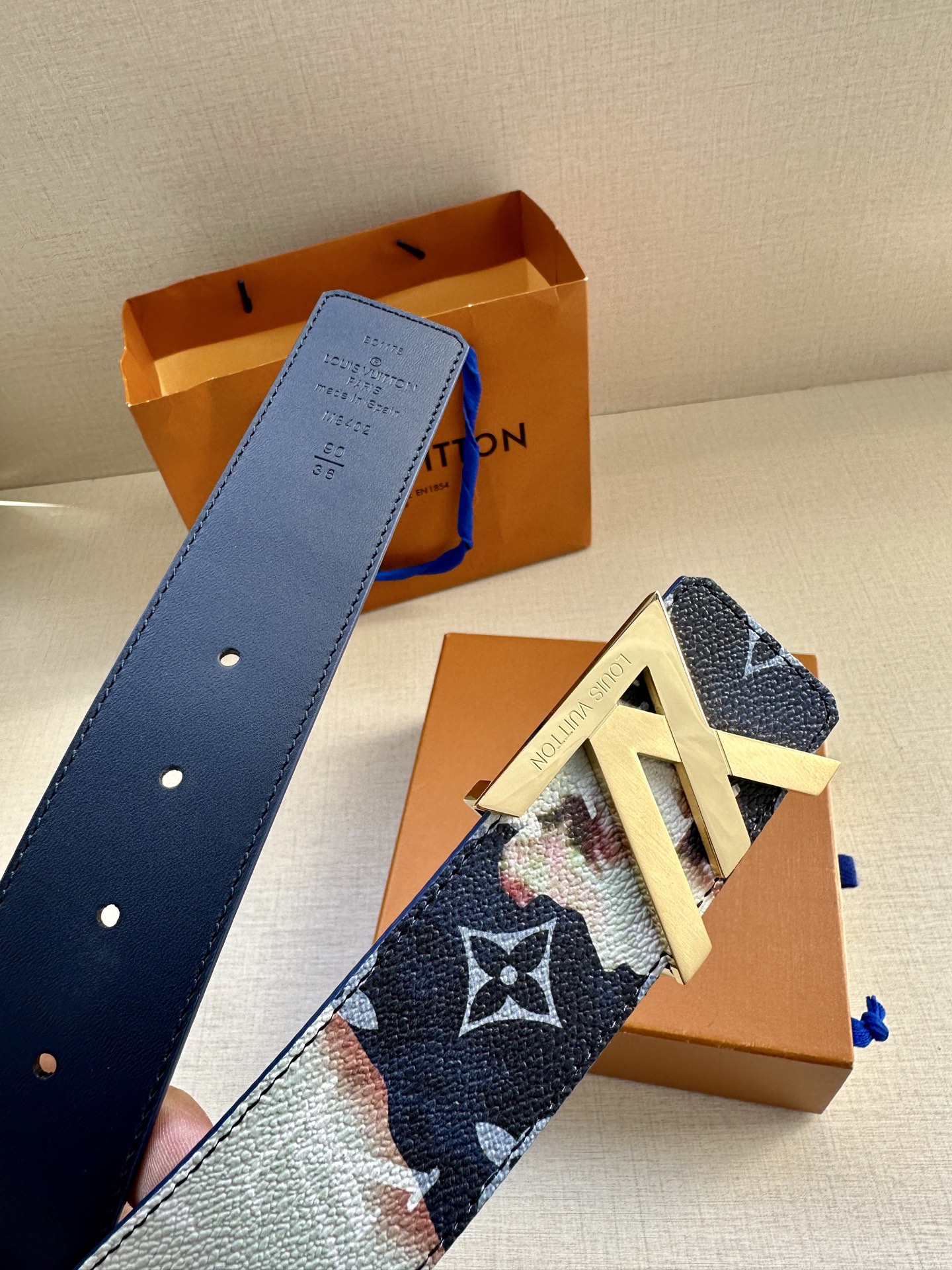  本款4.0宽LV Initials 双面腰带以醒目图案描摹烧焦的纸张，唤起对熊熊篝火和户外时光的回忆。