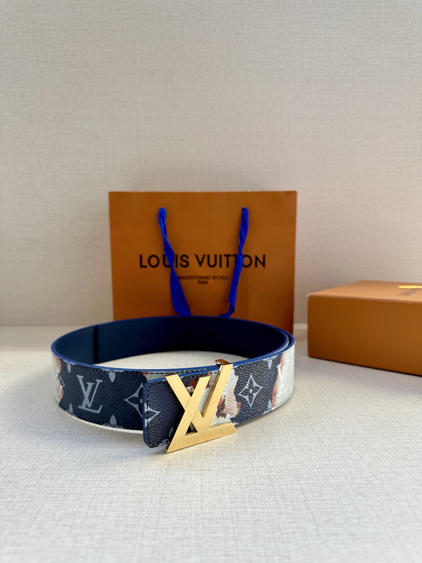  本款4.0宽LV Initials 双面腰带以醒目图案描摹烧焦的纸张，唤起对熊熊篝火和户外时光的回忆。