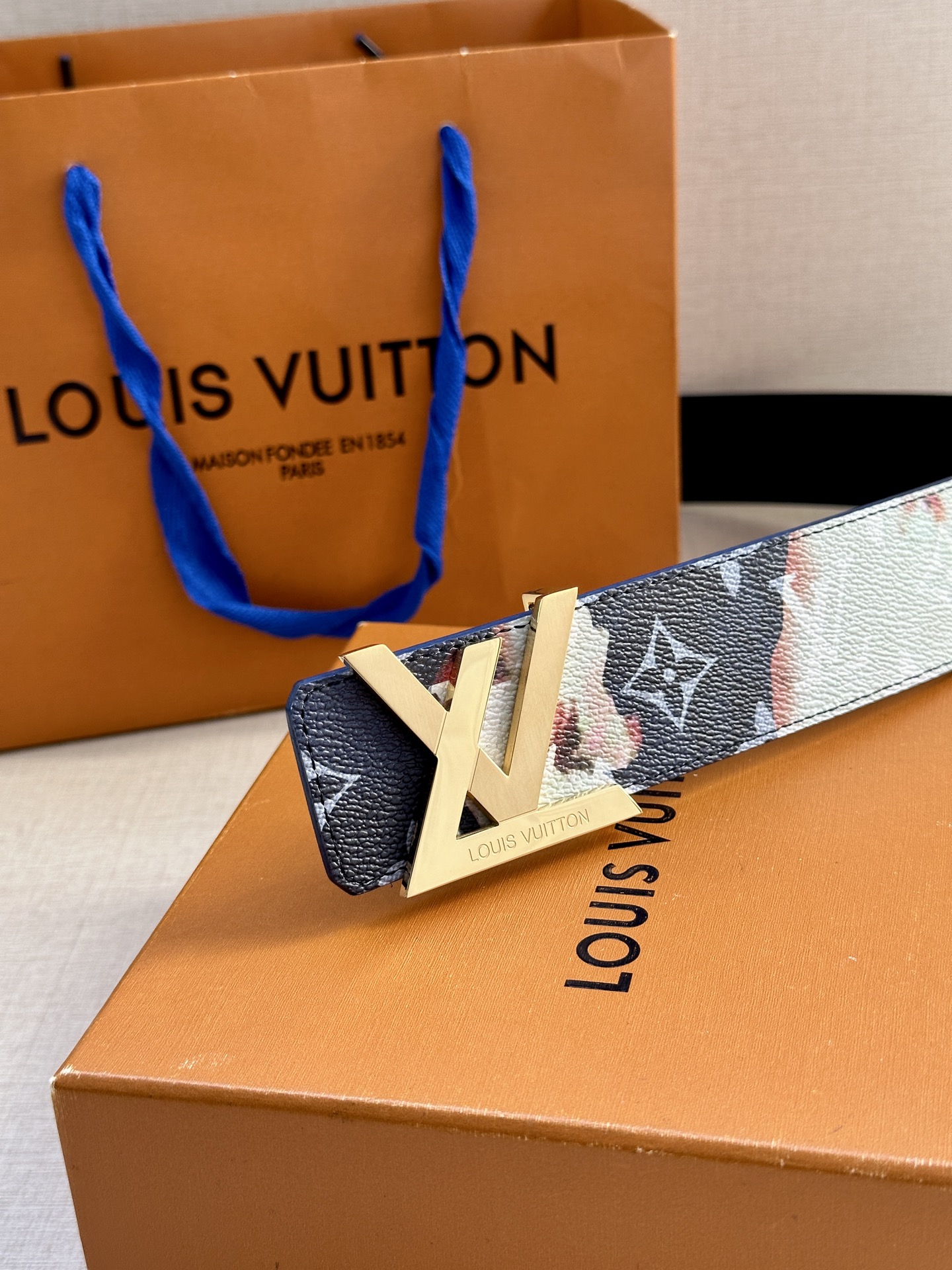  本款4.0宽LV Initials 双面腰带以醒目图案描摹烧焦的纸张，唤起对熊熊篝火和户外时光的回忆。