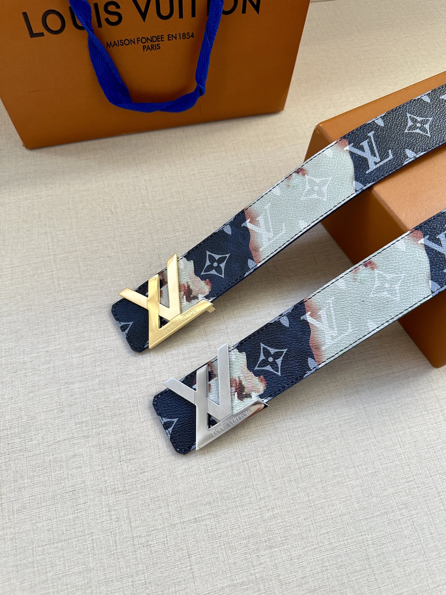  本款4.0宽LV Initials 双面腰带以醒目图案描摹烧焦的纸张，唤起对熊熊篝火和户外时光的回忆。