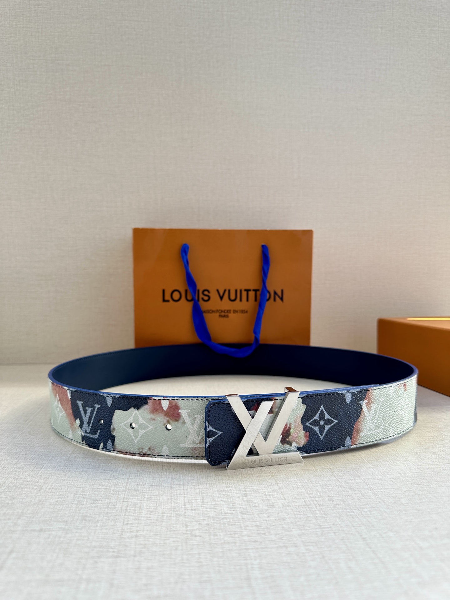  本款4.0宽LV Initials 双面腰带以醒目图案描摹烧焦的纸张，唤起对熊熊篝火和户外时光的回忆。