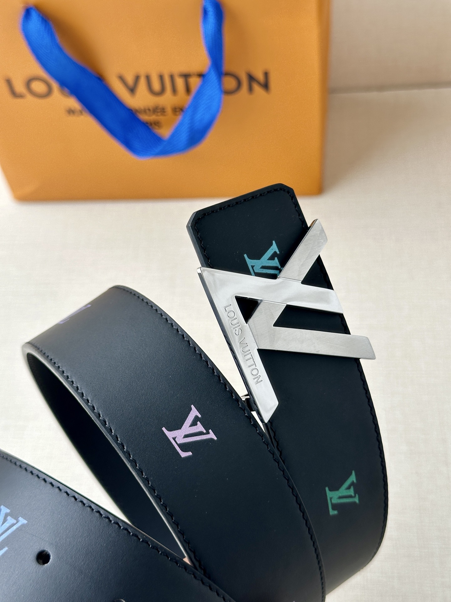  LV首字母4.0宽 是那些欣赏色彩的人的一种生动风格。表带的一面由黑色皮革制成，印有LV盾形图案，以彩