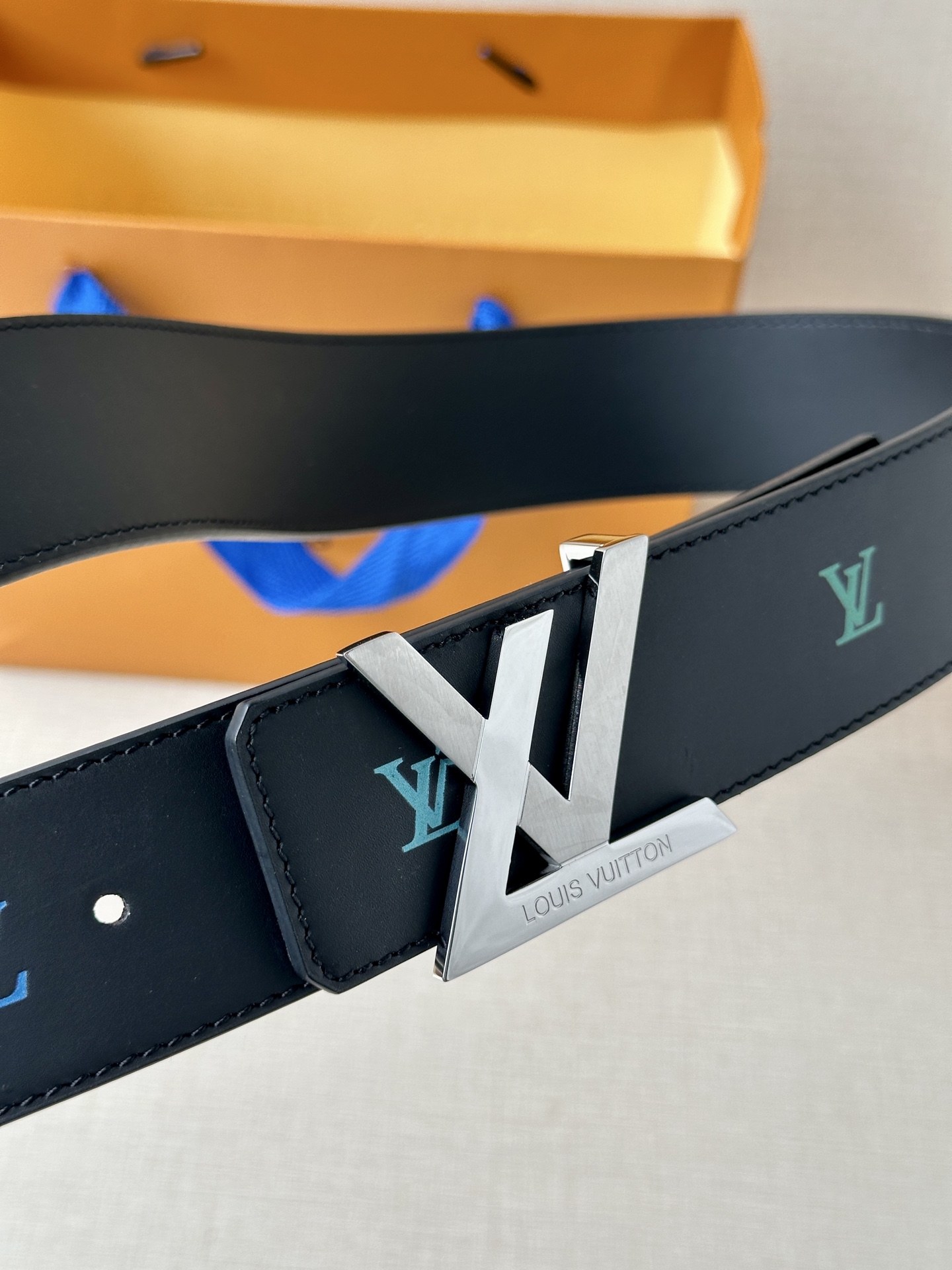  LV首字母4.0宽 是那些欣赏色彩的人的一种生动风格。表带的一面由黑色皮革制成，印有LV盾形图案，以彩