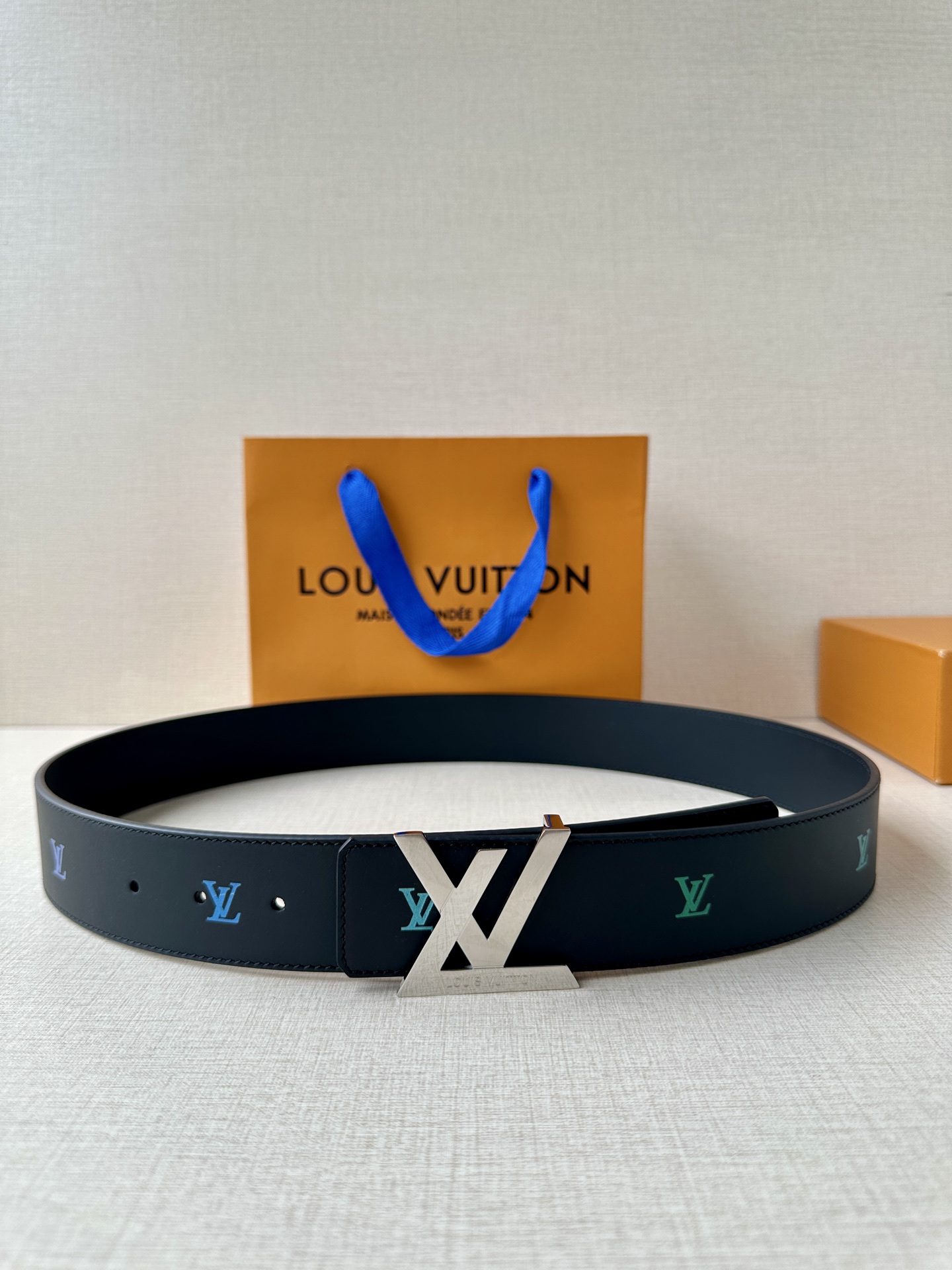  LV首字母4.0宽 是那些欣赏色彩的人的一种生动风格。表带的一面由黑色皮革制成，印有LV盾形图案，以彩