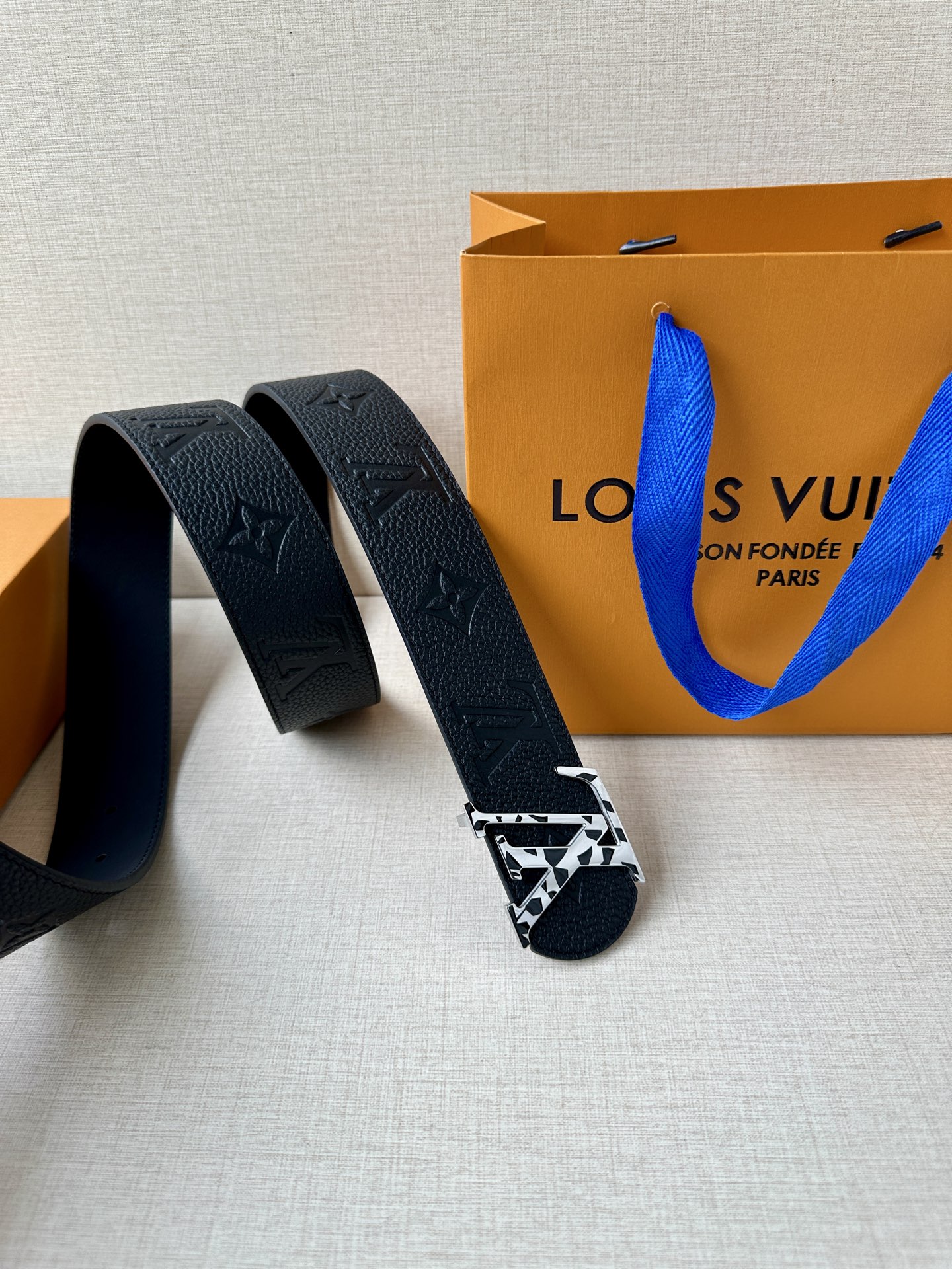  本款 Damier LV 40 毫米双面腰带做工精良，风格经典。深色牛皮革皮带与 LV 字母搭扣优雅相
