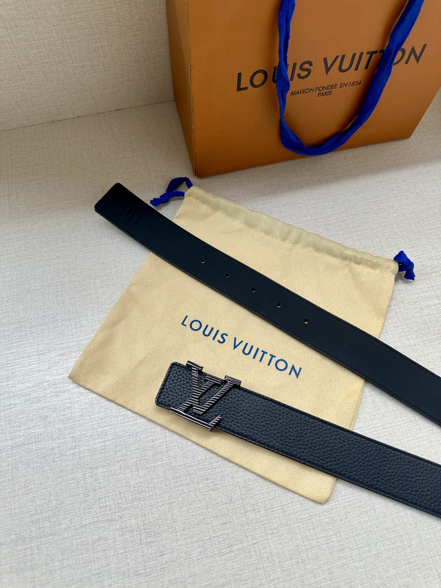 3.4宽 路易威登经典元素。中央 LV 字母搭扣释放瞩目哑光亮泽。双面牛皮革点缀精雅 Monogram 