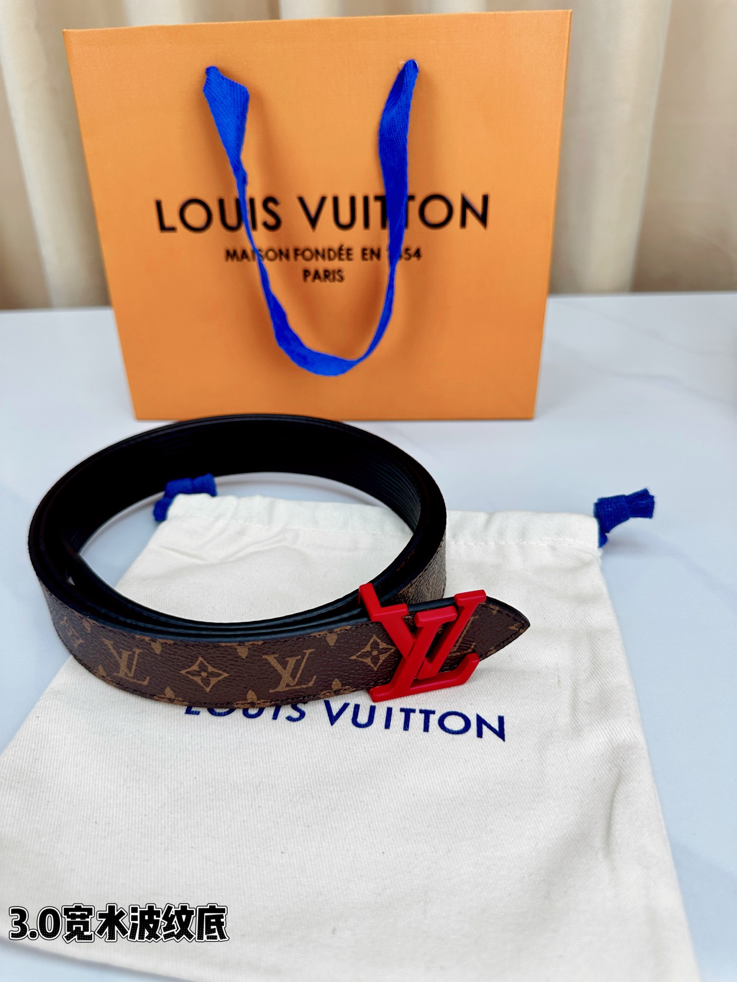 经典棕底水波纹压花邂逅亮眼红扣，3.0cm宽幅设计勾勒腰线。LV标志性字母扣点缀，皮革触感细腻。1854