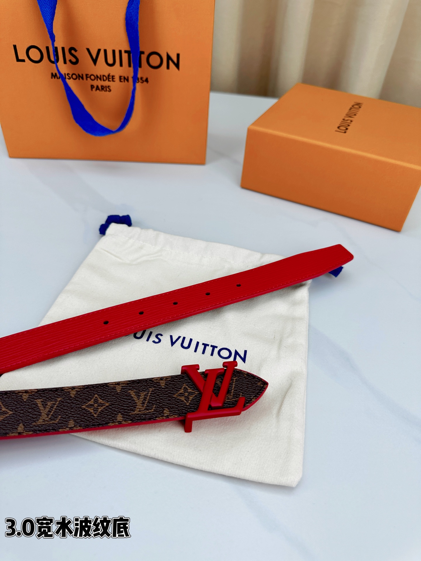 经典棕底水波纹压花邂逅亮眼红扣，3.0cm宽幅设计勾勒腰线。LV标志性字母扣点缀，皮革触感细腻。1854