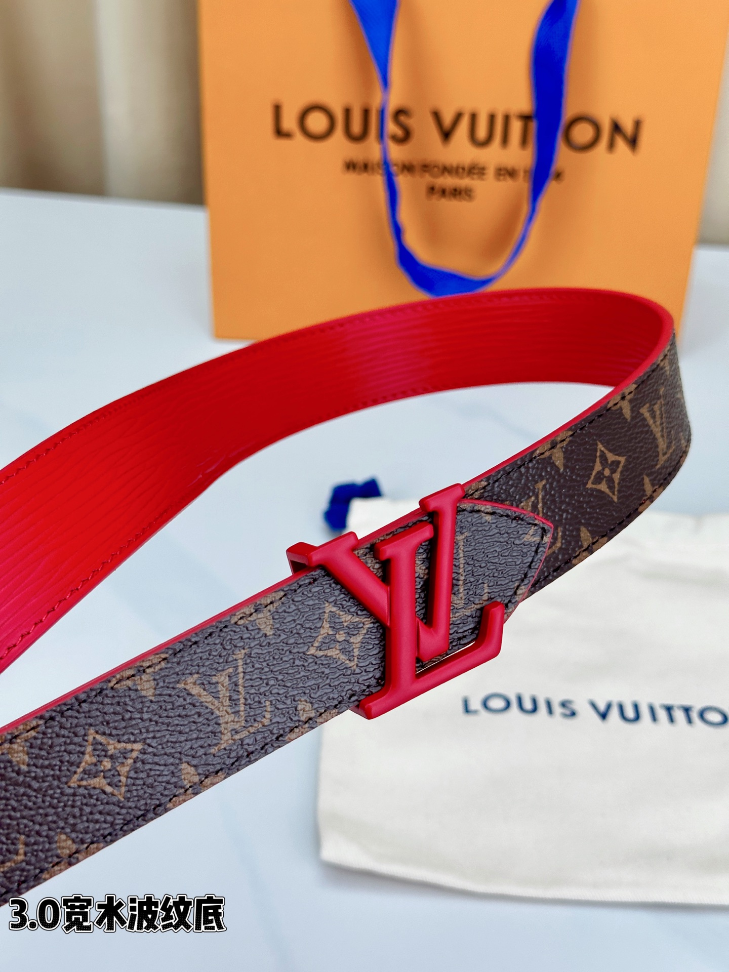 经典棕底水波纹压花邂逅亮眼红扣，3.0cm宽幅设计勾勒腰线。LV标志性字母扣点缀，皮革触感细腻。1854