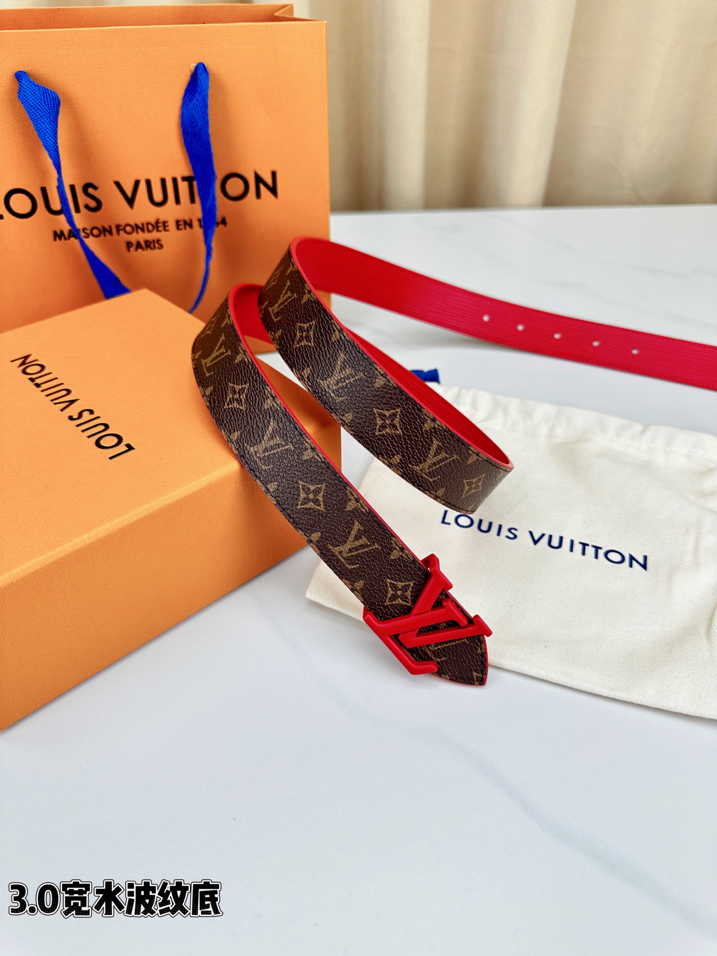 经典棕底水波纹压花邂逅亮眼红扣，3.0cm宽幅设计勾勒腰线。LV标志性字母扣点缀，皮革触感细腻。1854