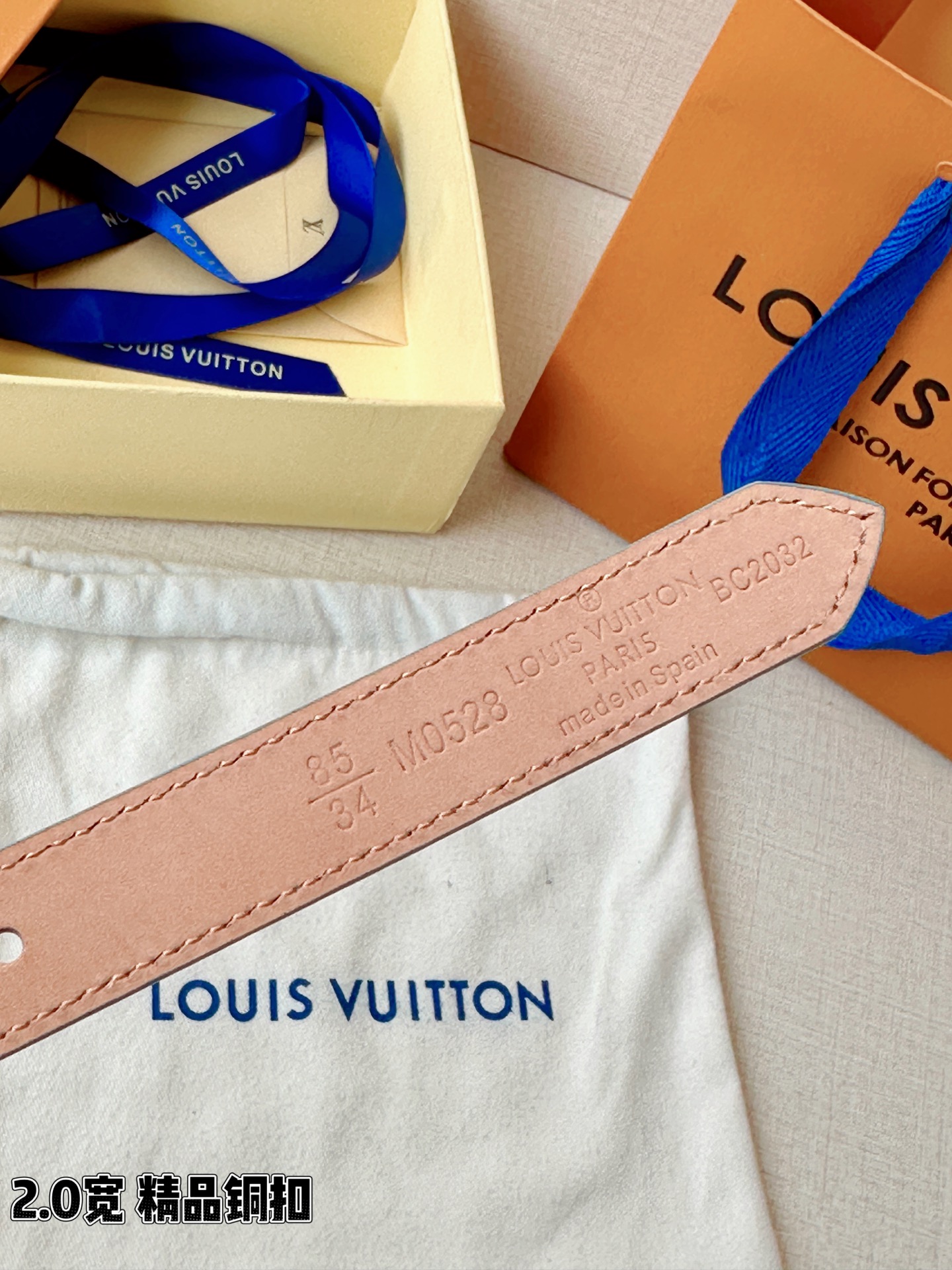 浅蓝色与米白色压纹皮革交织，2.0厘米纤细宽度勾勒腰线。金色铜质四叶花扣头，镌刻经典LV字母与菱形暗纹，