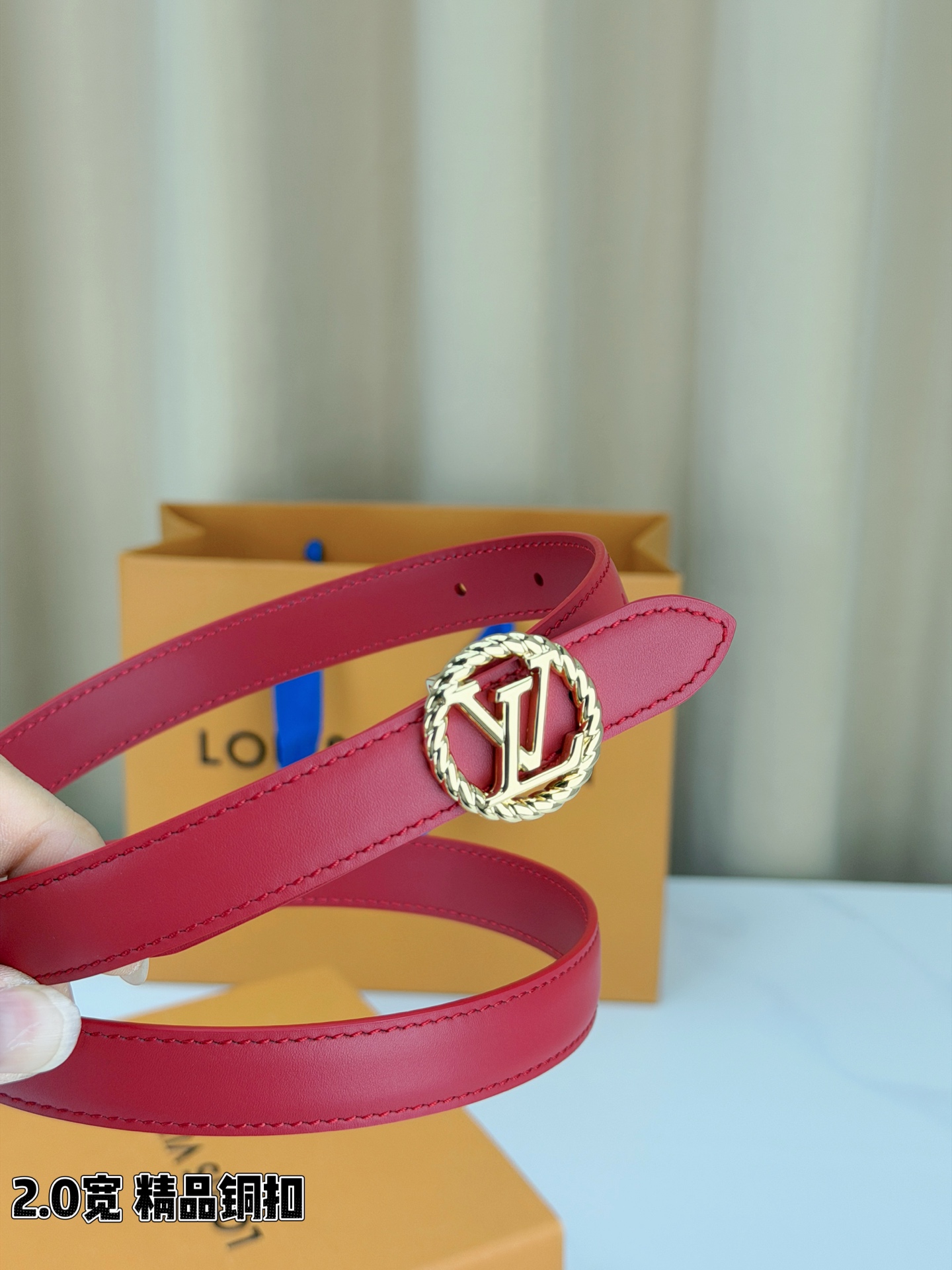路易威登2.0宽细腰带，麻花辫扭纹铜扣缀以镂空LV标识，金色光泽温婉流转。红黑双色可选，皮革细腻柔软，同