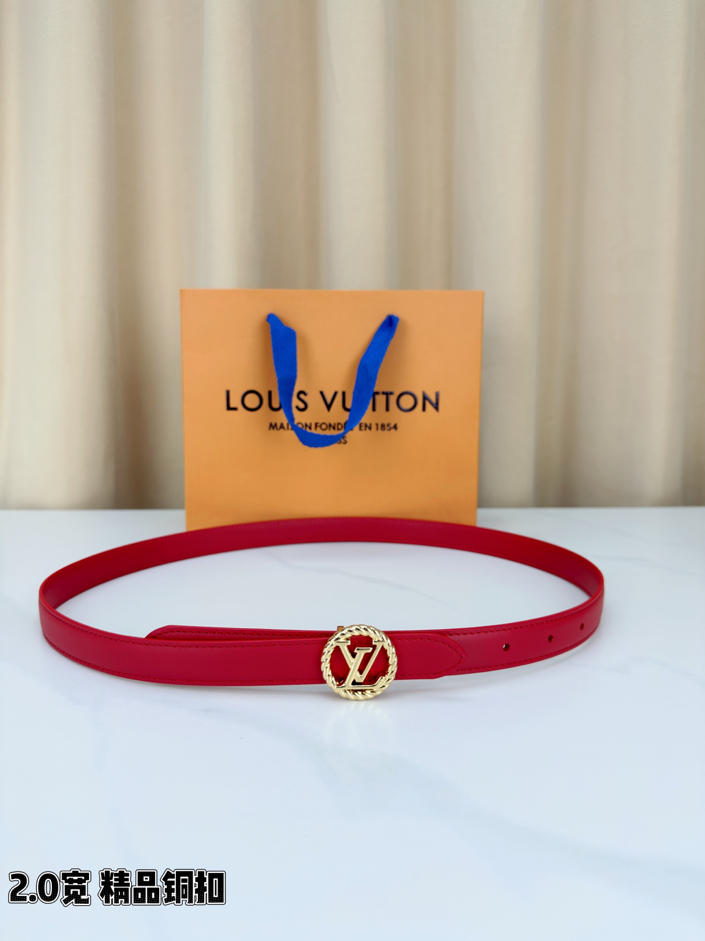 路易威登2.0宽细腰带，麻花辫扭纹铜扣缀以镂空LV标识，金色光泽温婉流转。红黑双色可选，皮革细腻柔软，同