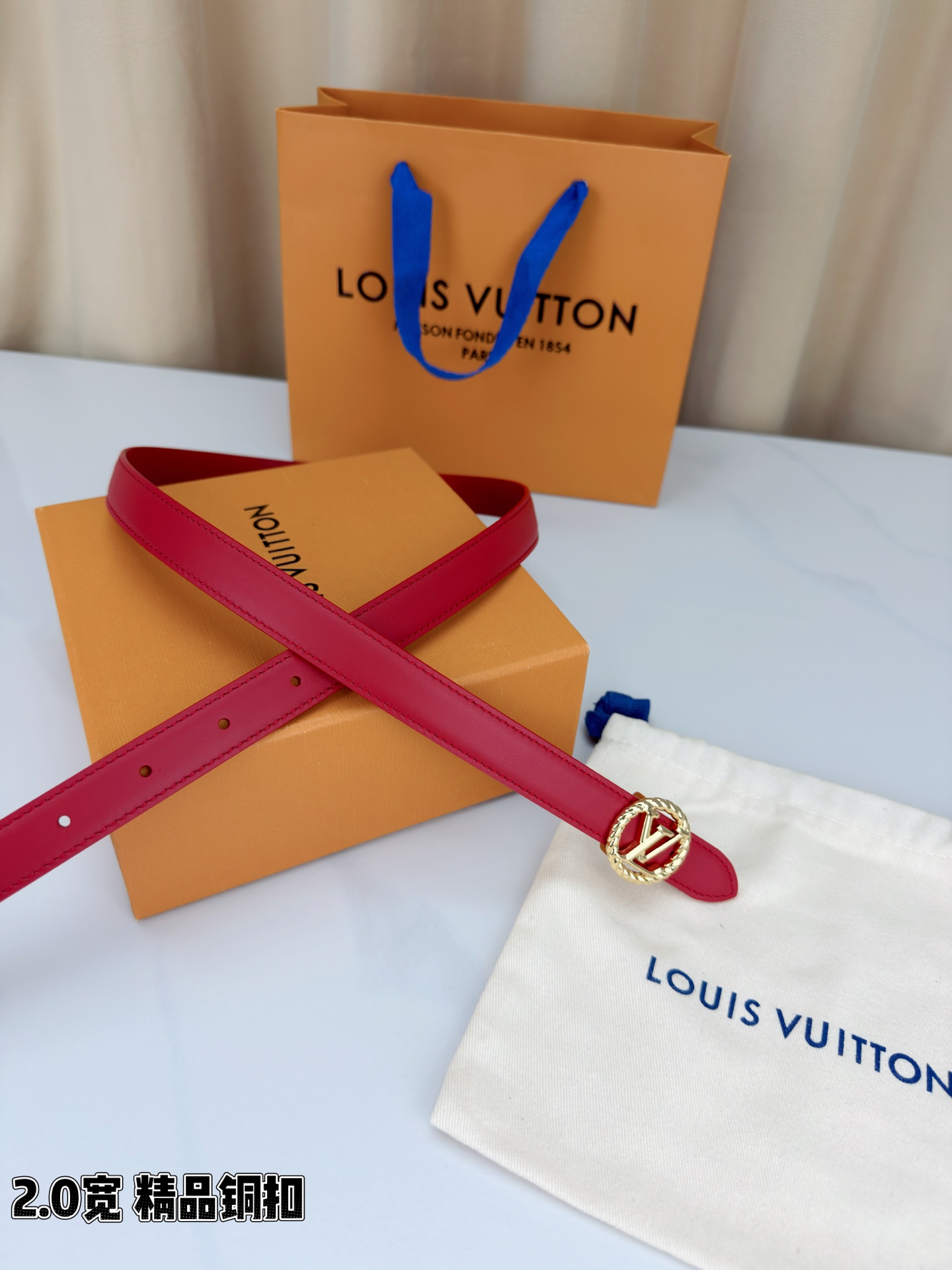 路易威登2.0宽细腰带，麻花辫扭纹铜扣缀以镂空LV标识，金色光泽温婉流转。红黑双色可选，皮革细腻柔软，同